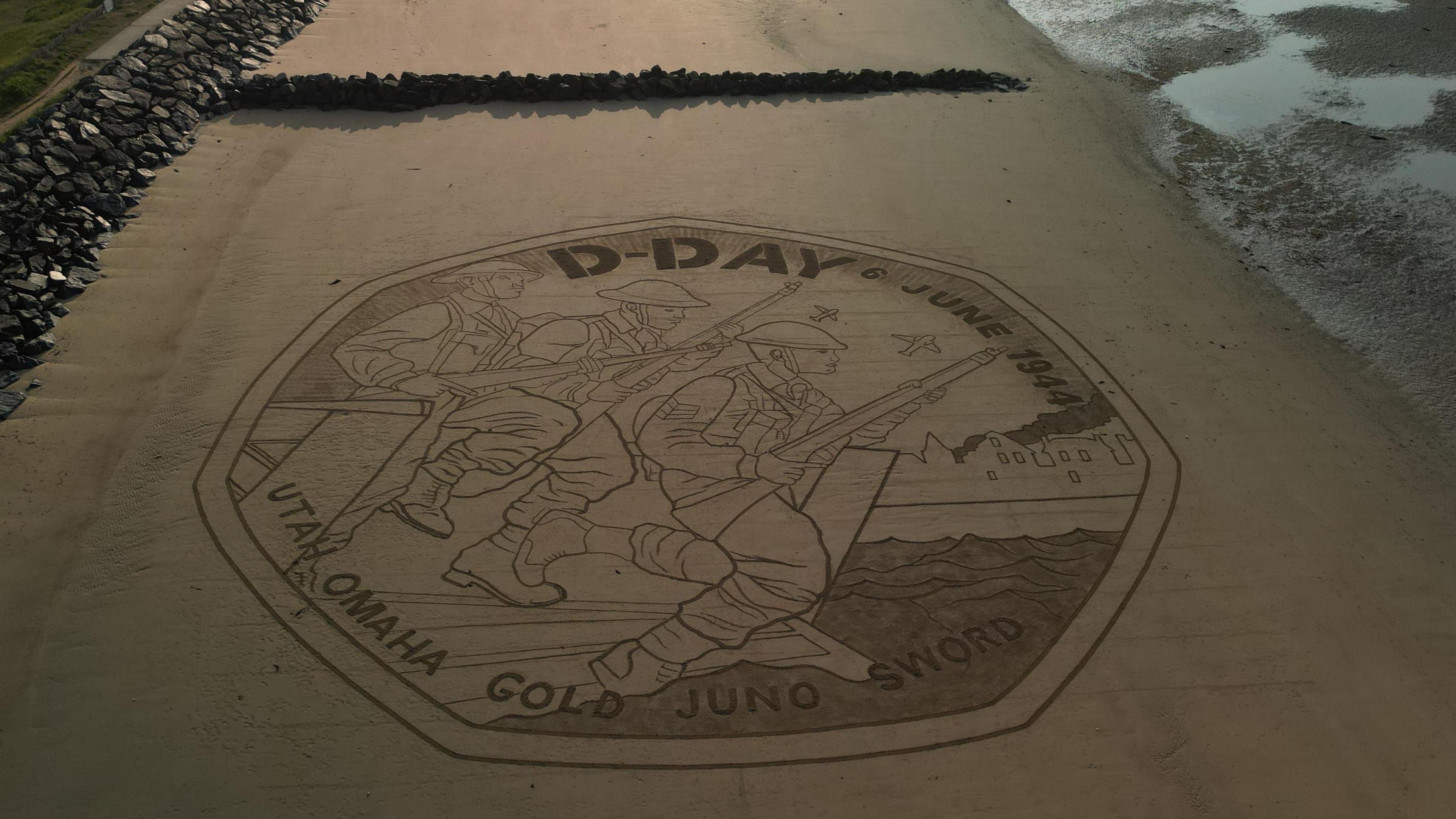 The D-Day coin design has been recreated on Gold beach.