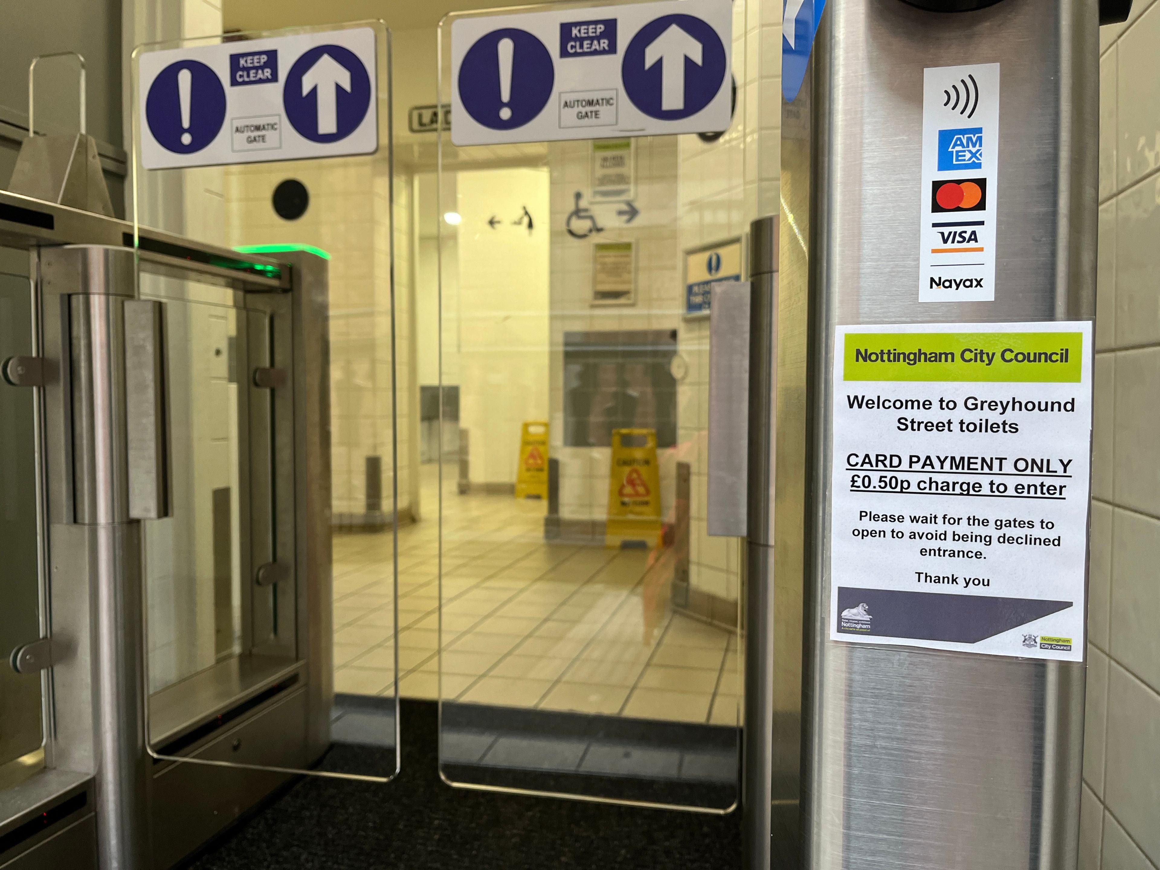 Public toilet entrance with sign warning users of 50p charge