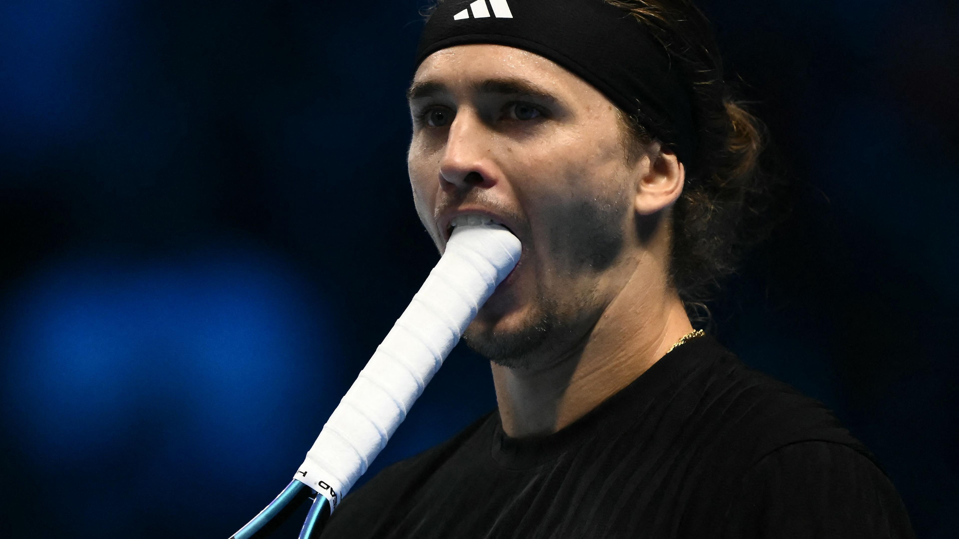Alexander Zverev bites his racquet after missing a break point against Jannik Sinner at the ATP Finals