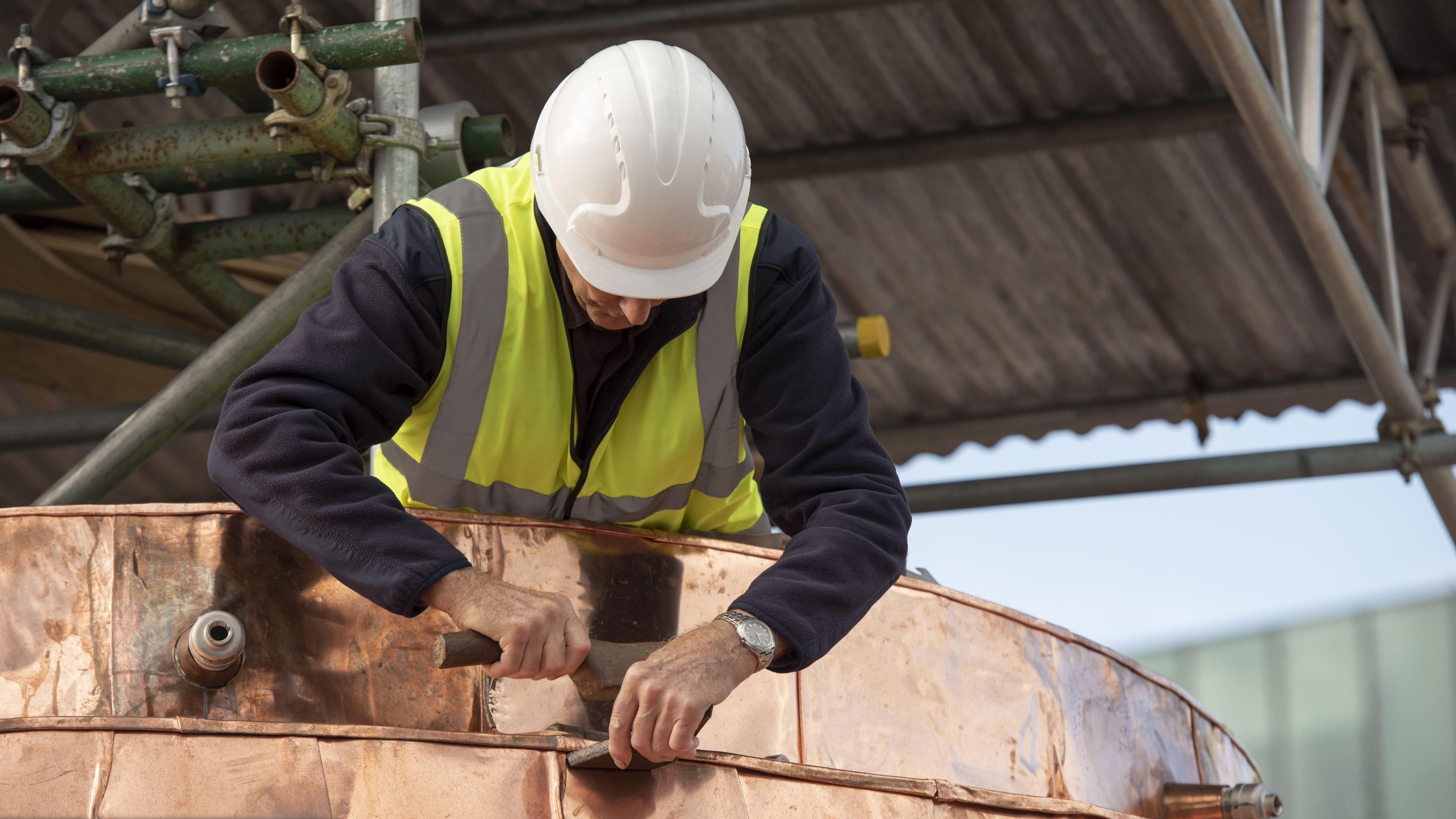 A man works on a copper section of the General Market