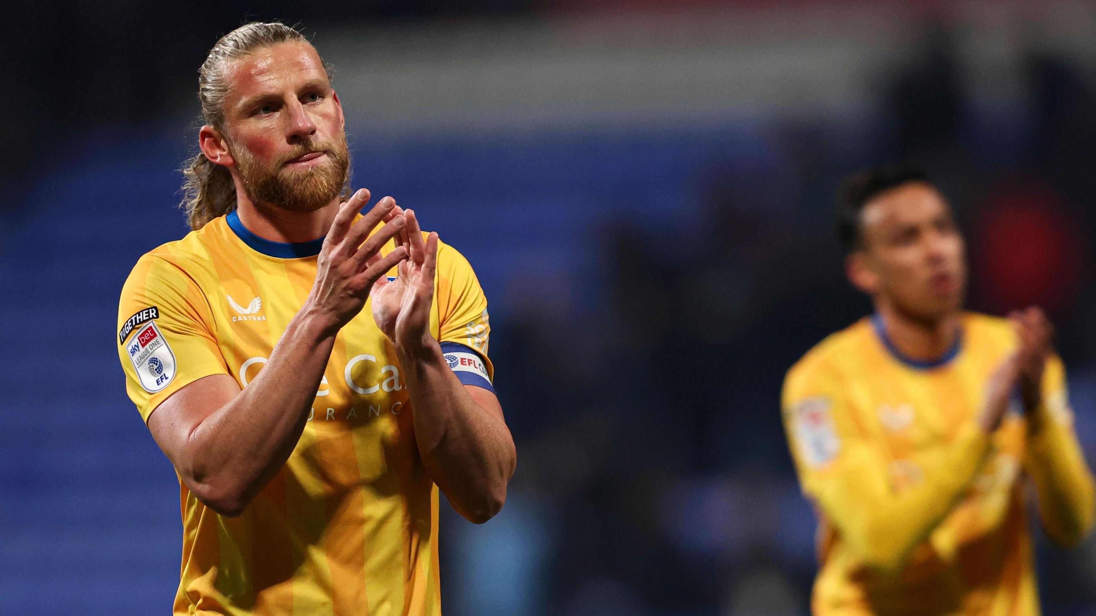 Alfie Kilgour applauds Mansfield fans after a match