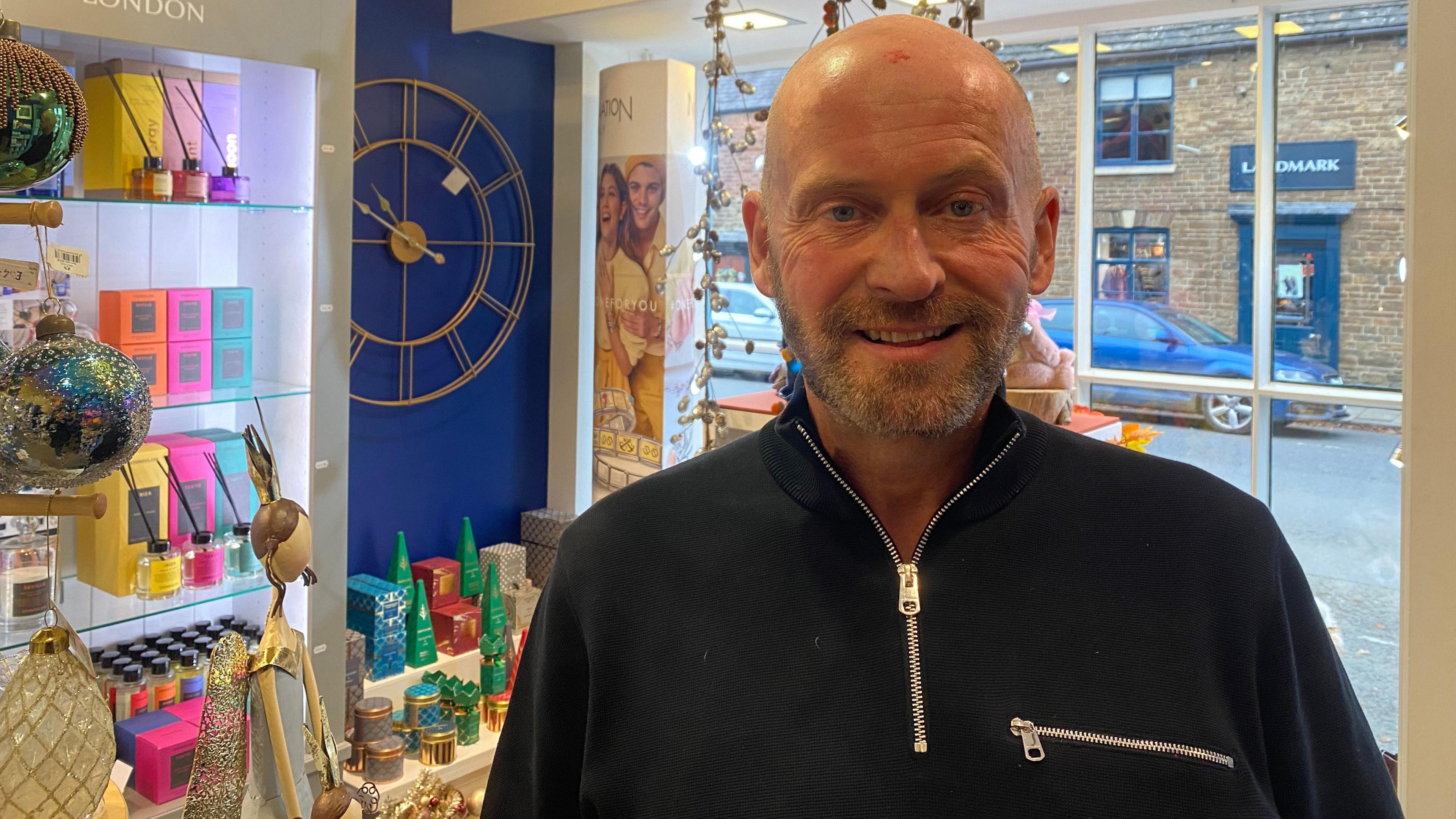 Craig Smith in his gift store on Mill Street with Christmas products in the background. 