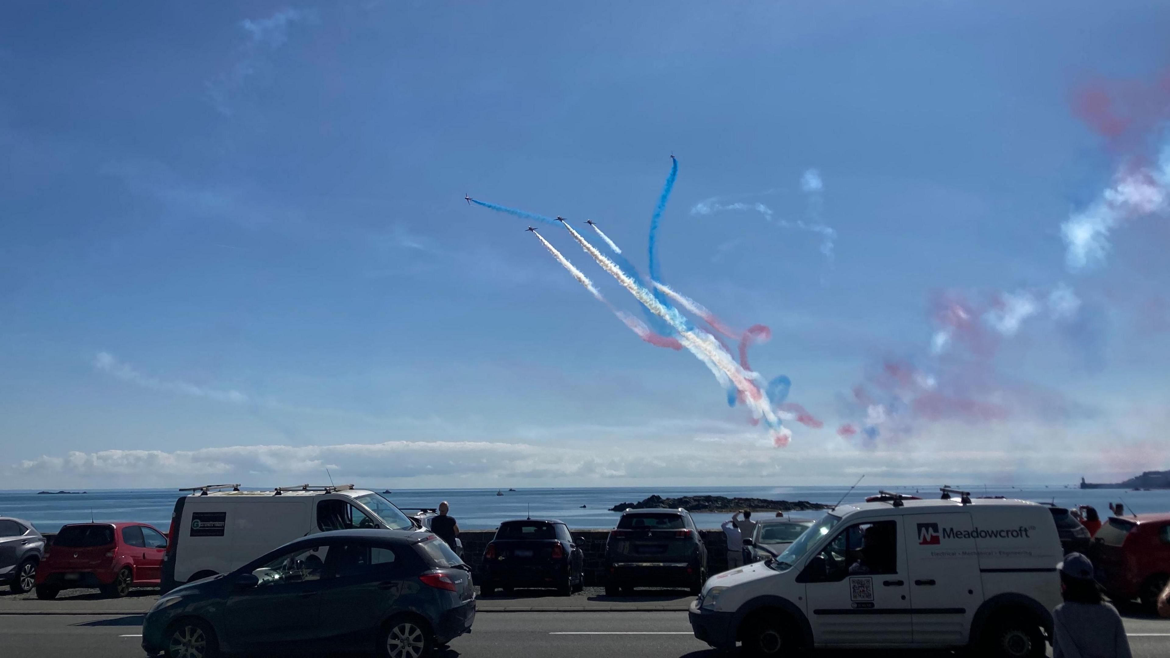 Cars and people watching Red Arrows