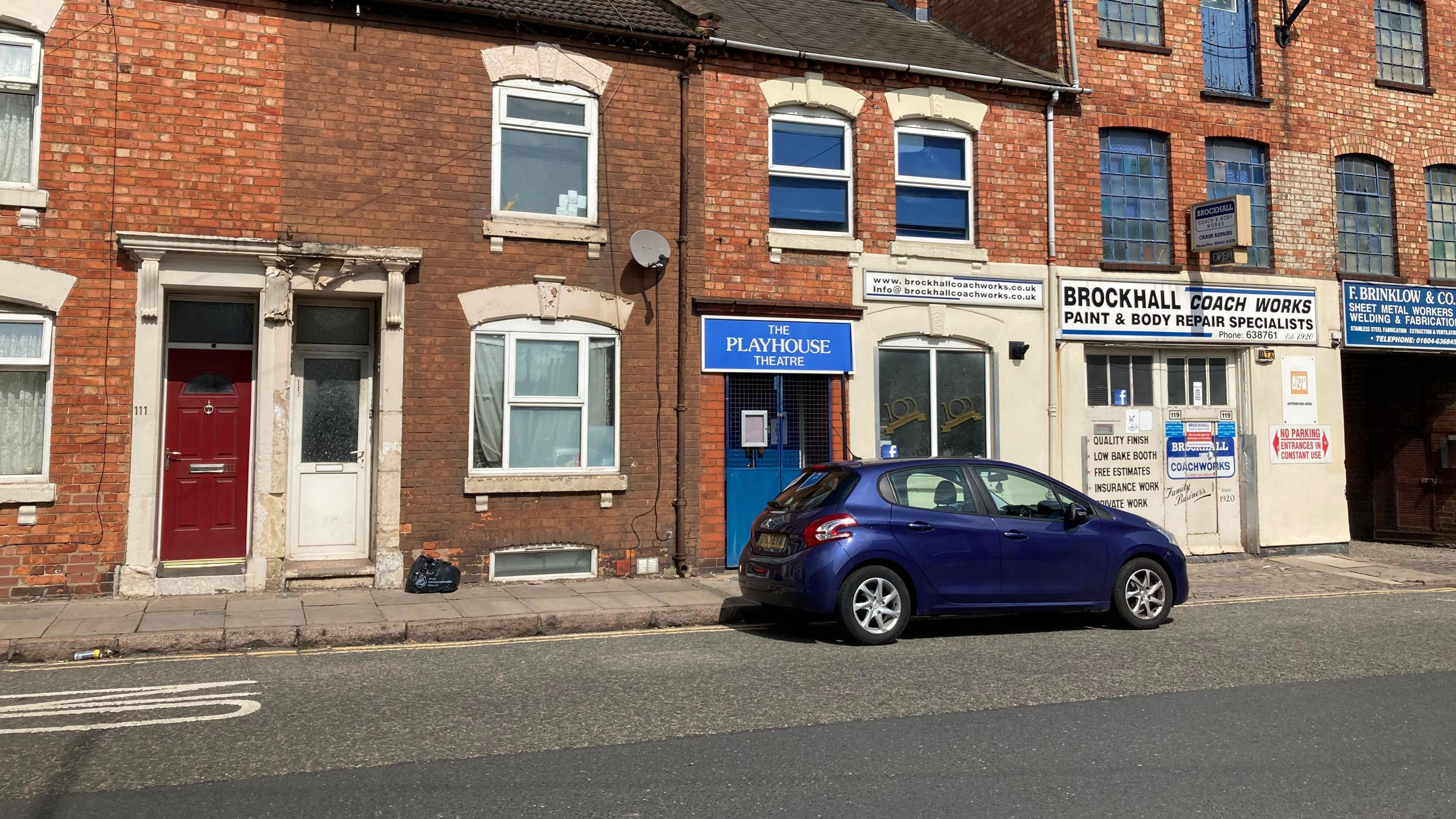 A street view photo of where the Playhouse Theatre was situated - as part of a terrace between houses and a car body shop. 