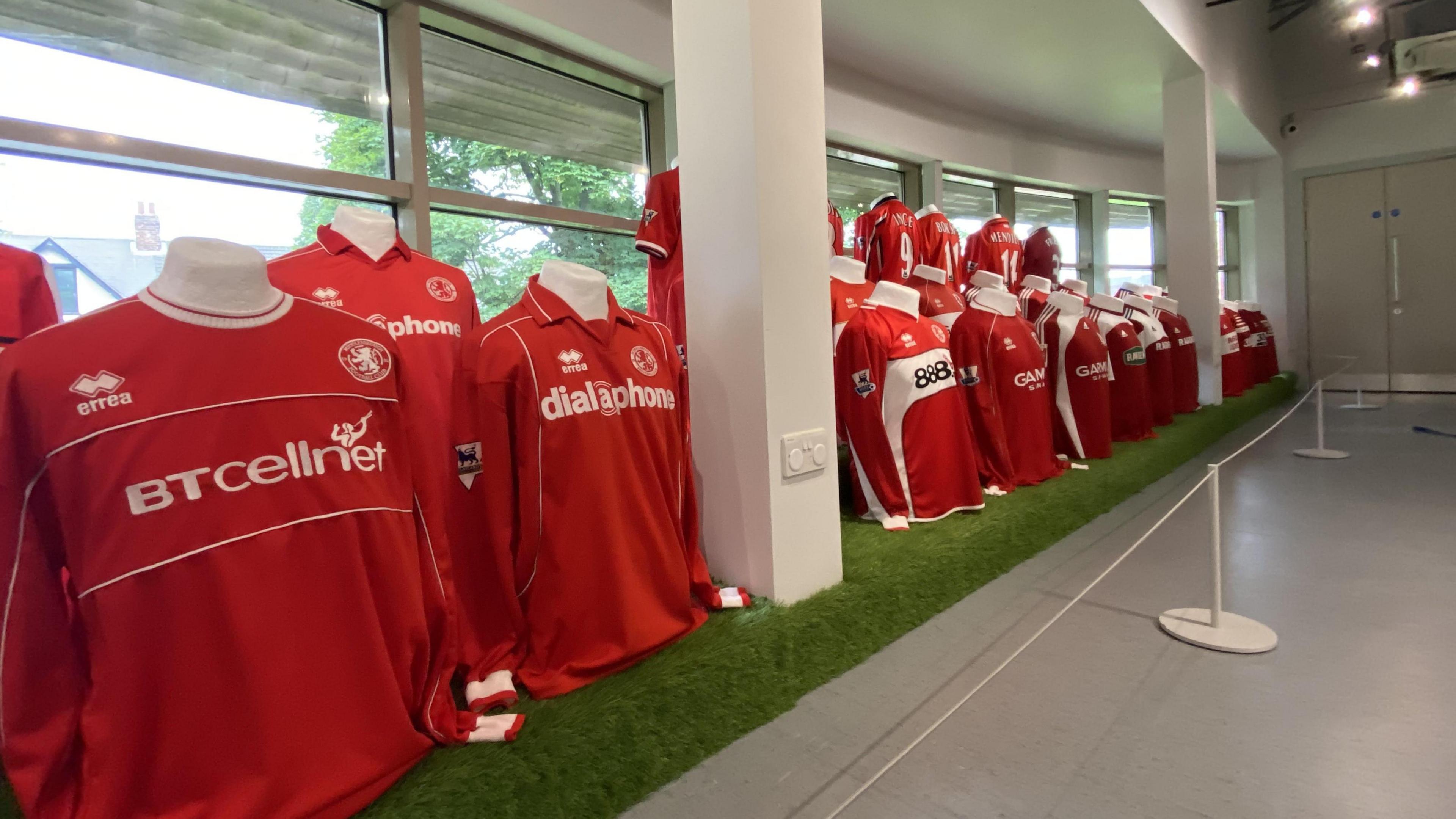 A line of Middlesbrough FC shirts in a window at the Dorman Museum.