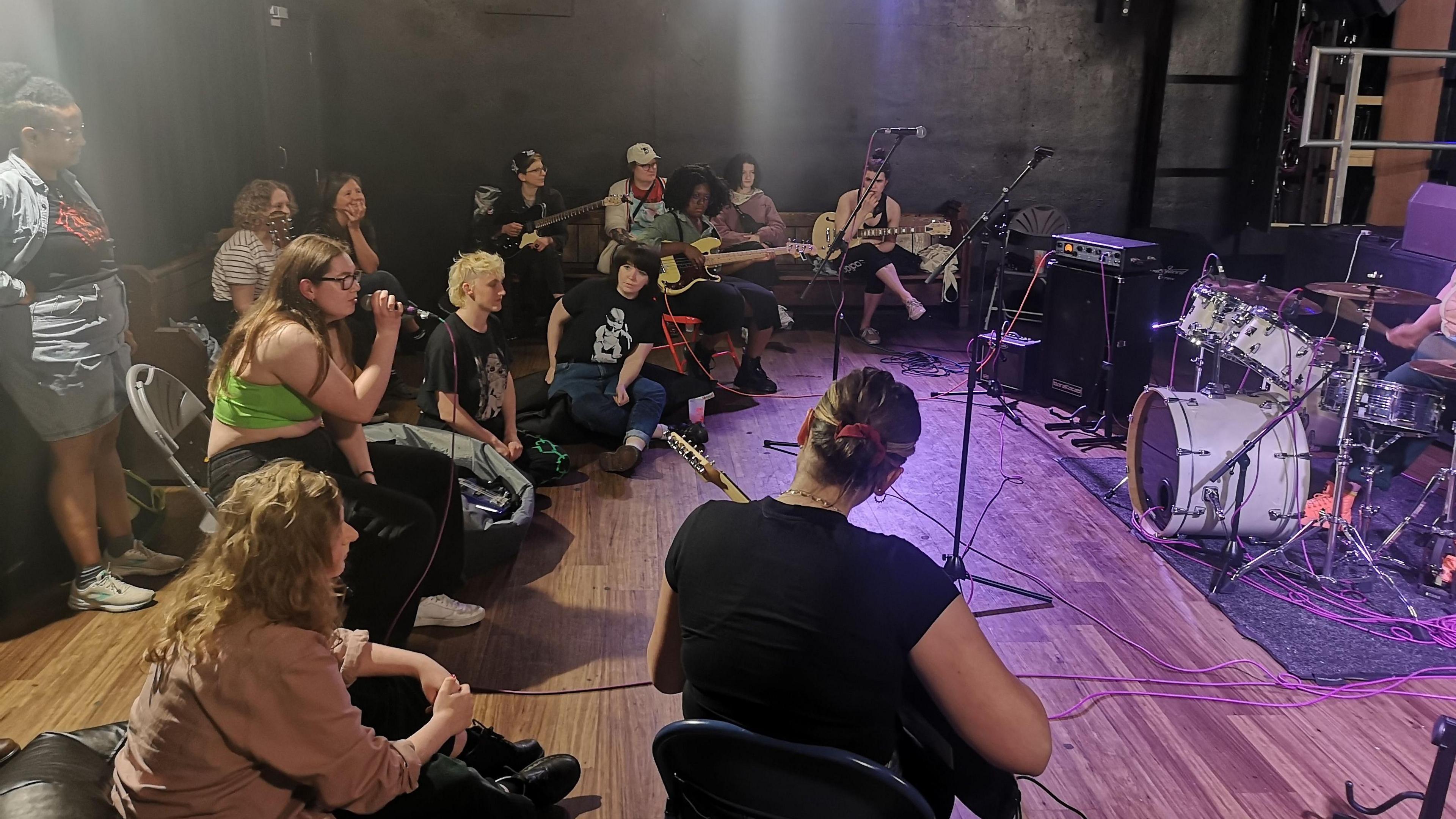 People sitting around a circle playing music