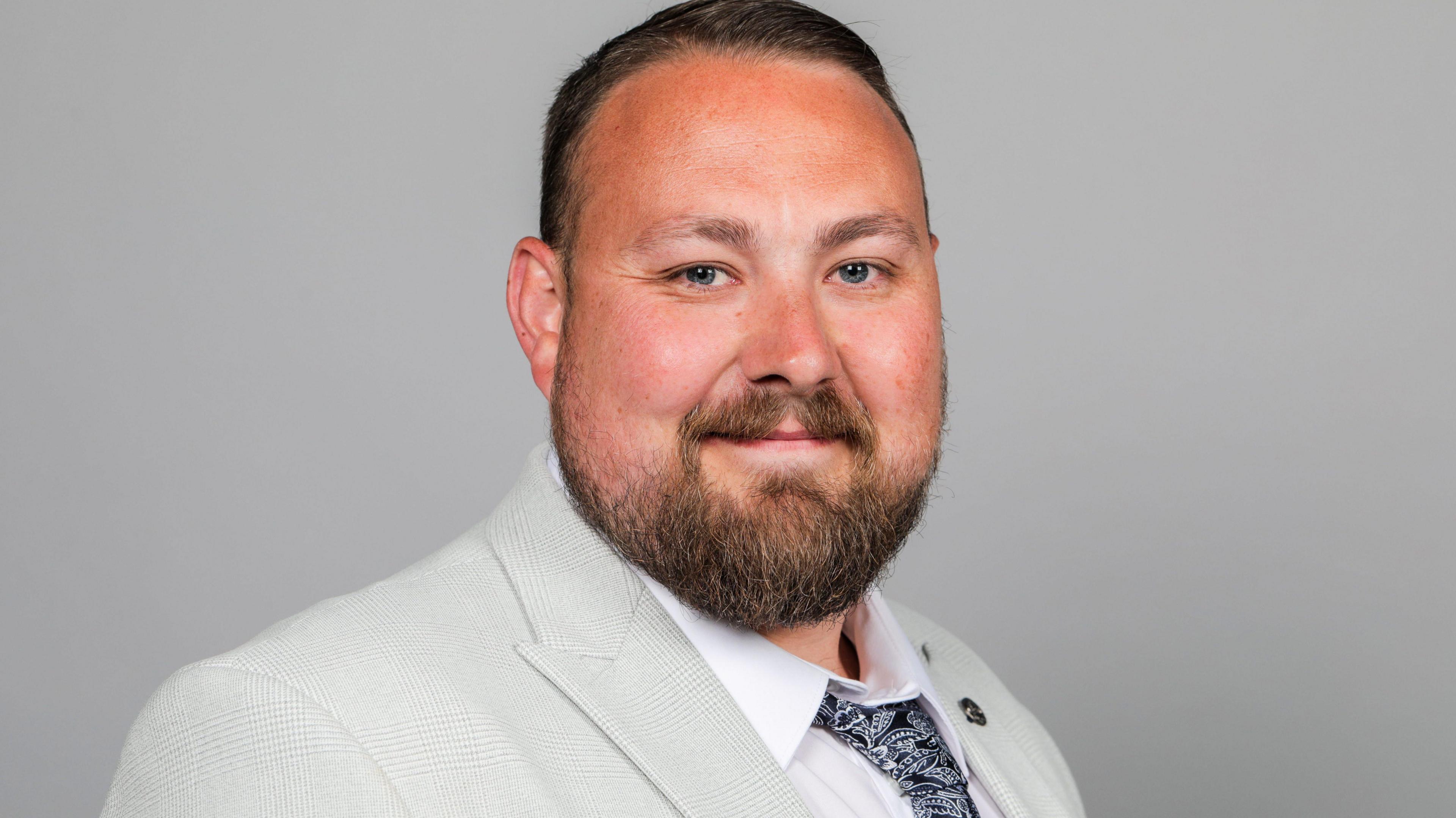 Councillor Adam Brook, the cabinet member for neighbourhoods at Redcar and Cleveland Council. He wears a white pleated suit.