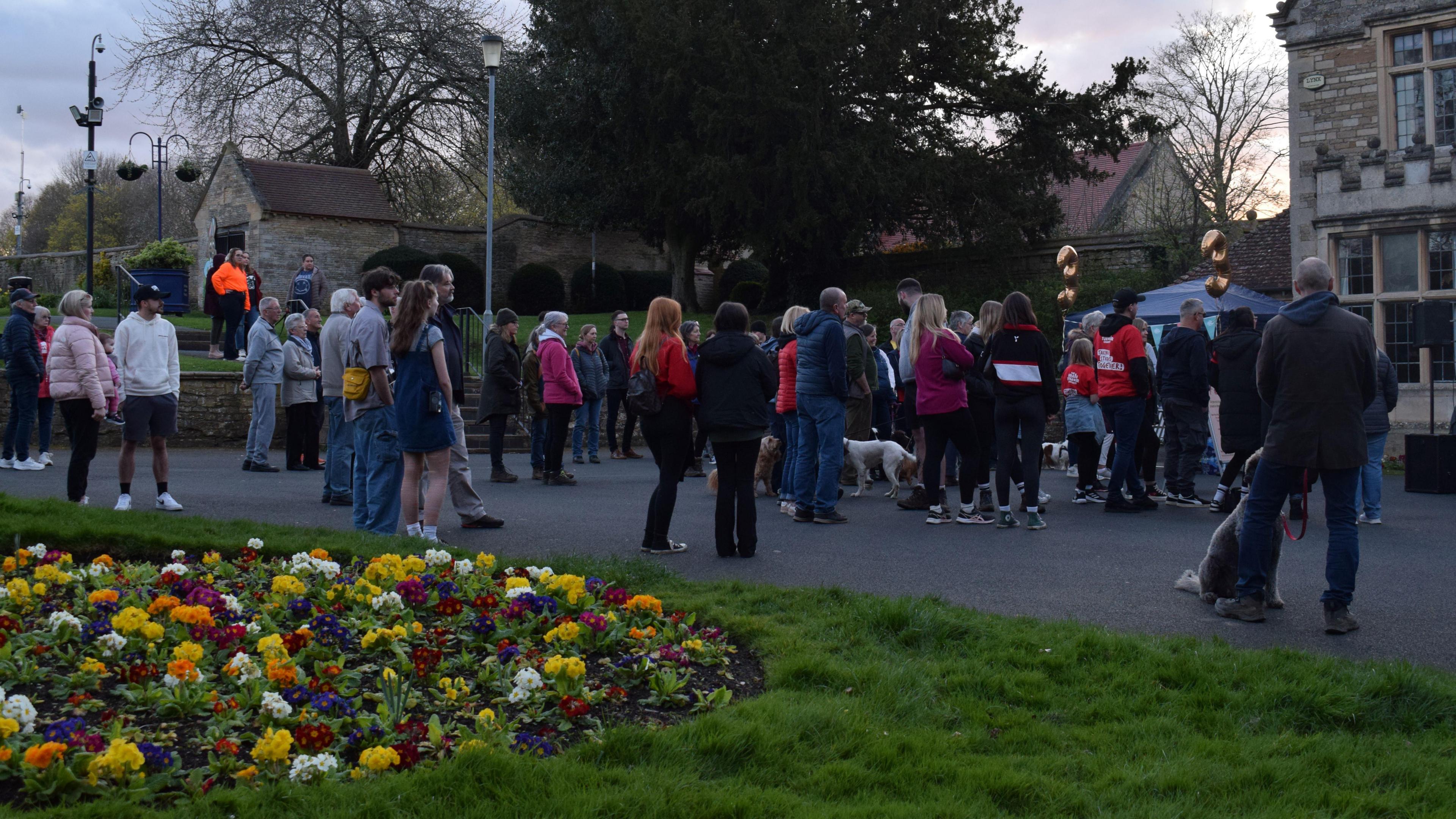 A group of people gathering for a walk in Rushden's Hall Park