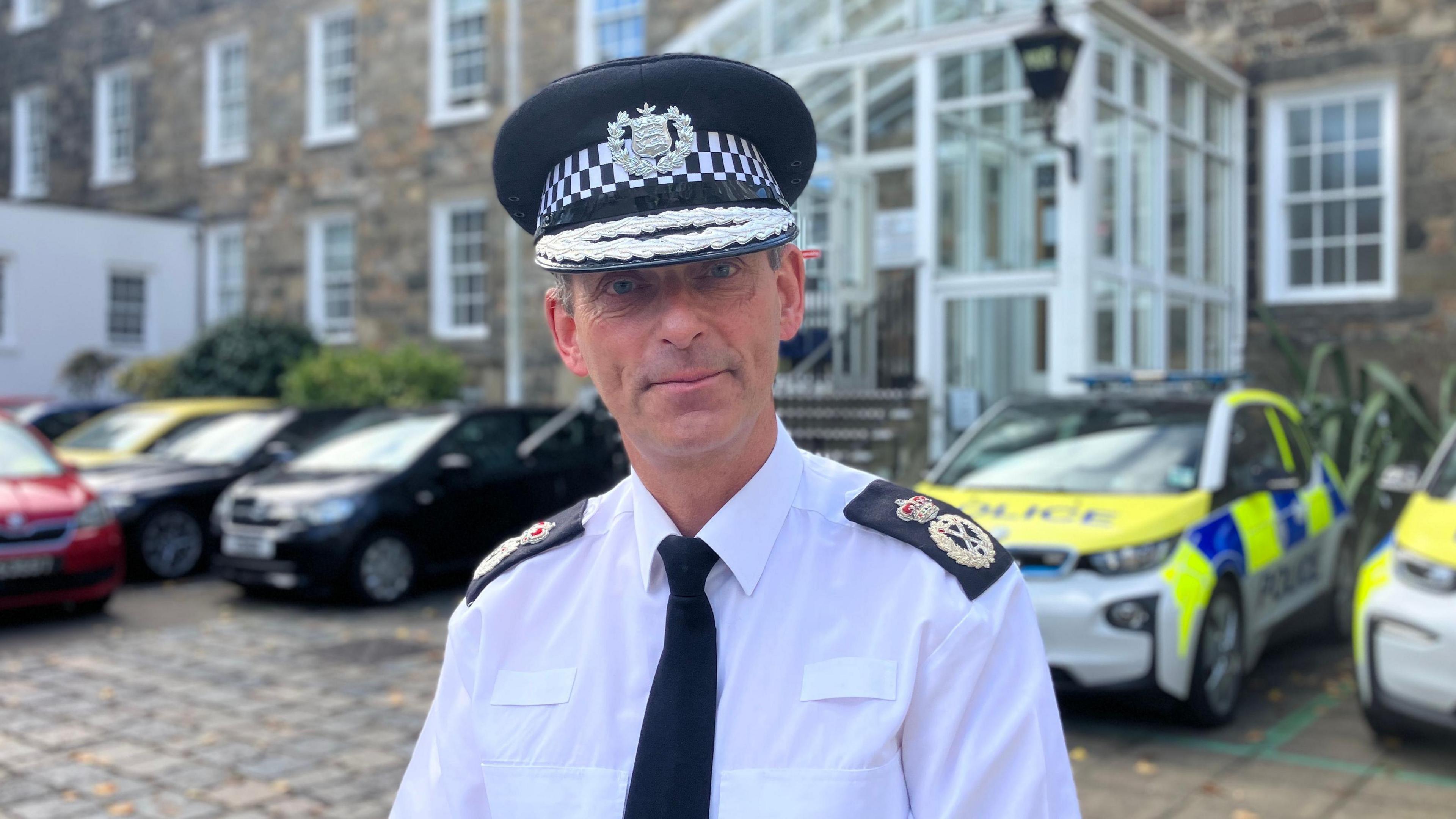 Police chief stands in uniform outside Guernsey Police headquarters