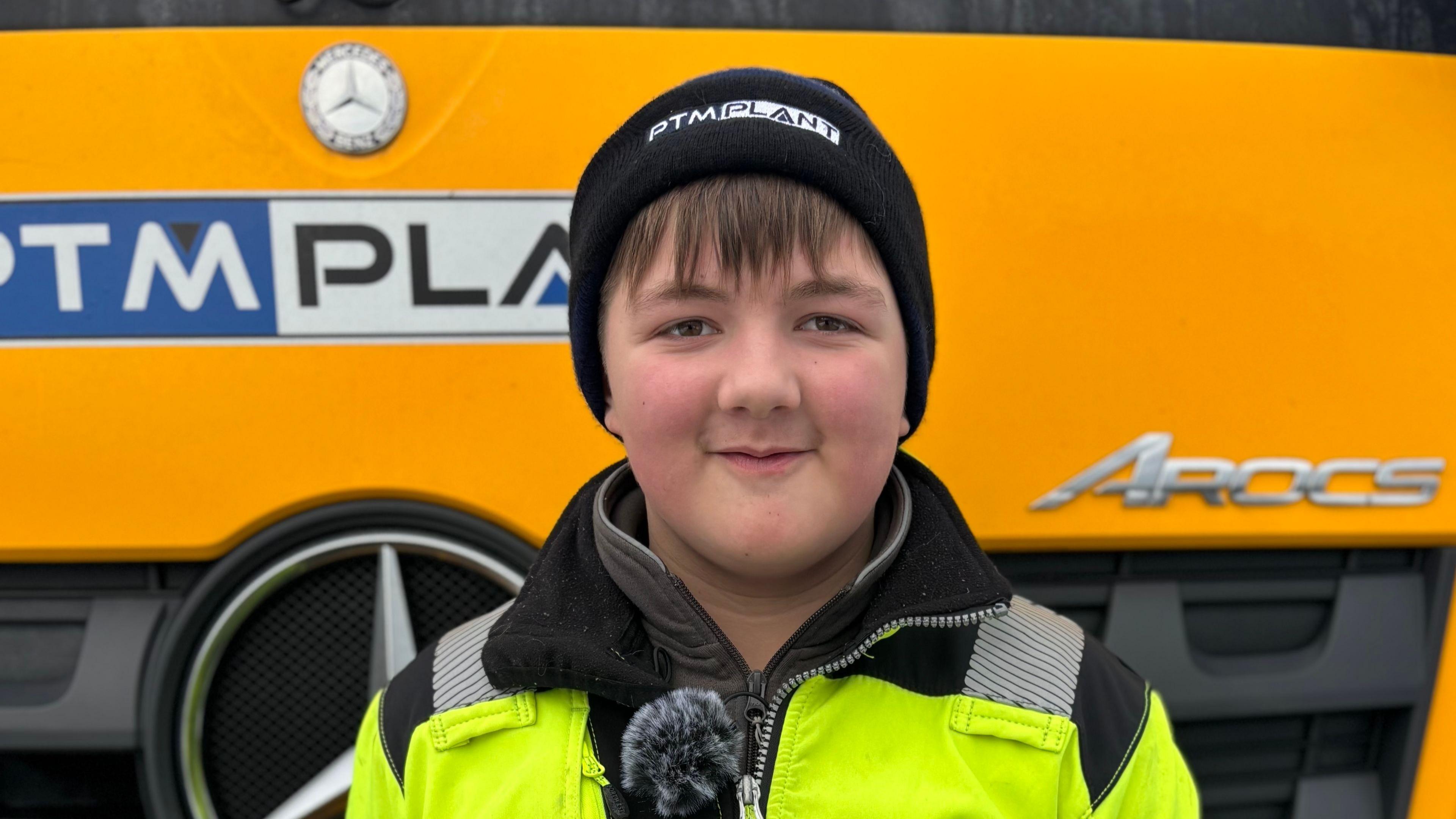 Jamie Monaghan, a teenage boy, is wearing a black woolly hat and a yellow high-vis jacket.