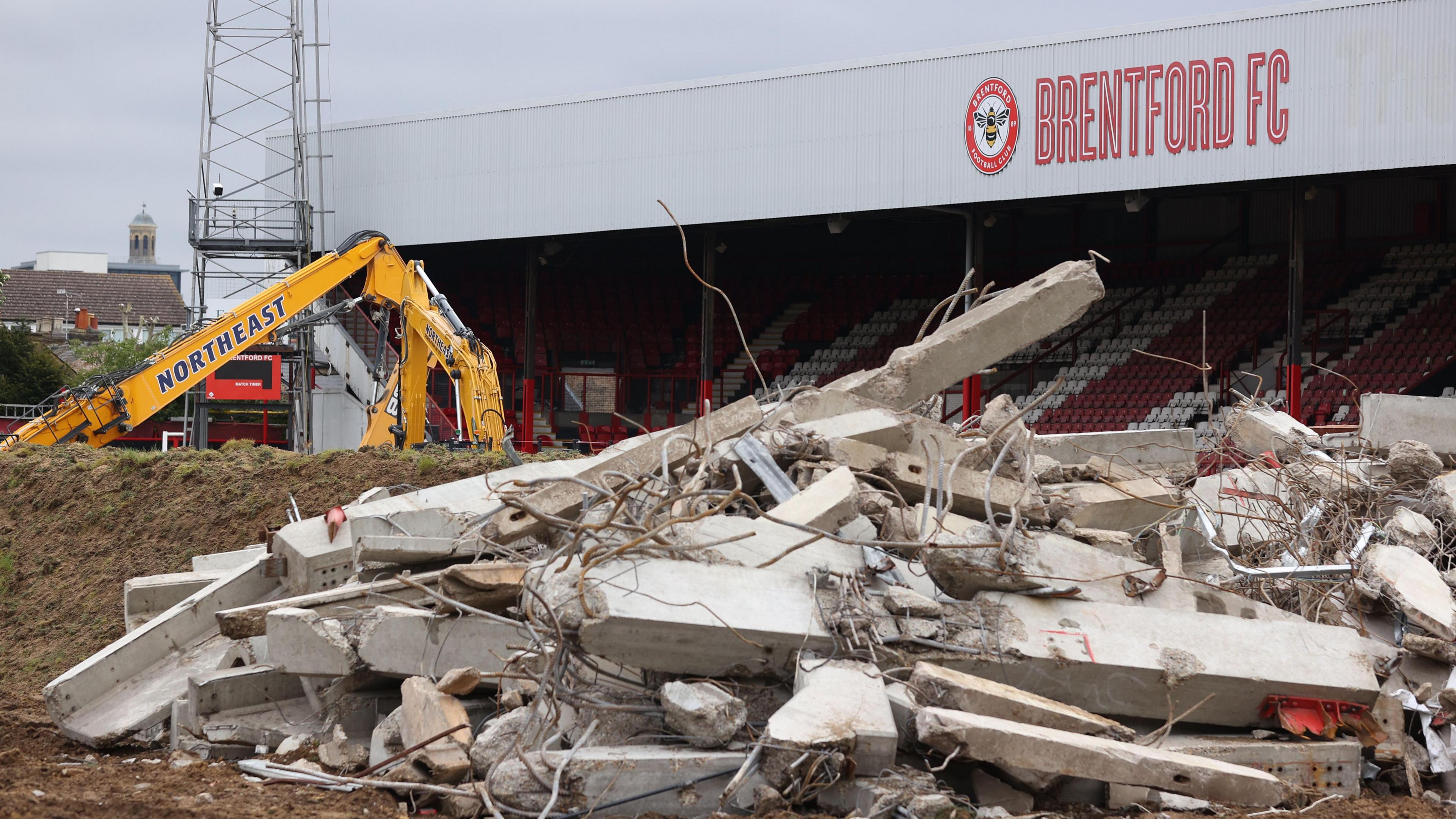 Demolished property and a digger at the Brentford FC stadium. 