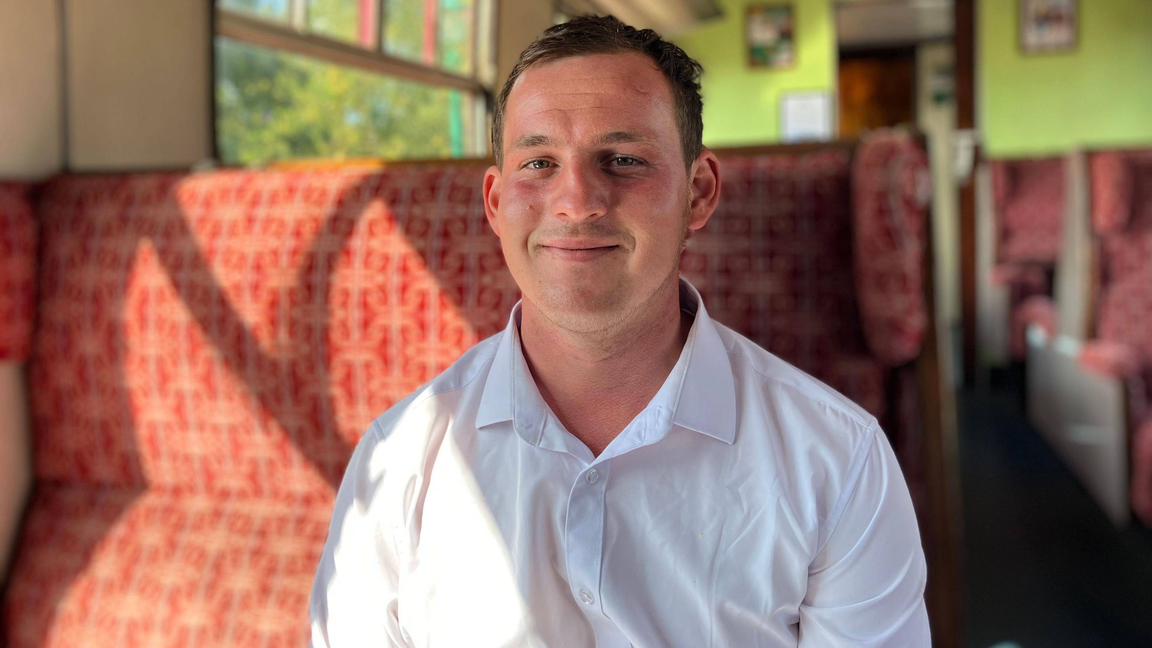 Robert Bentley has short dark hair and is wearing a white shirt. He is smiling and sitting in the exact same old-fashioned seat as Sandra Bullock and Nicole Kidman.