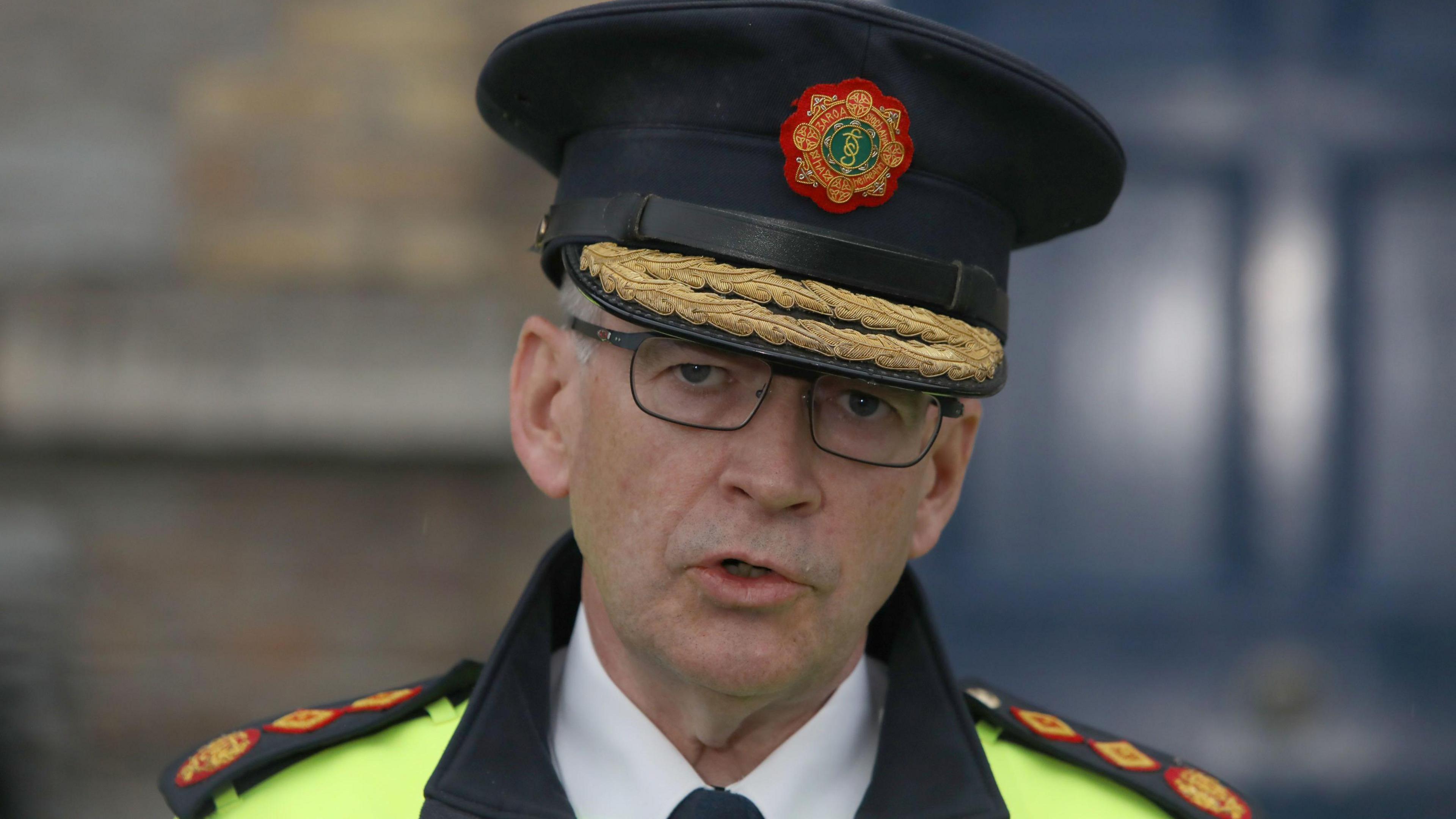 Garda Commissioner Drew Harris speaking to the media at Garda headquarters in Dublin after Irish police officer Kevin Flatley was killed at a checkpoint in Dublin after being struck by a motorbike. He is wearing his garda hat and glasses.
