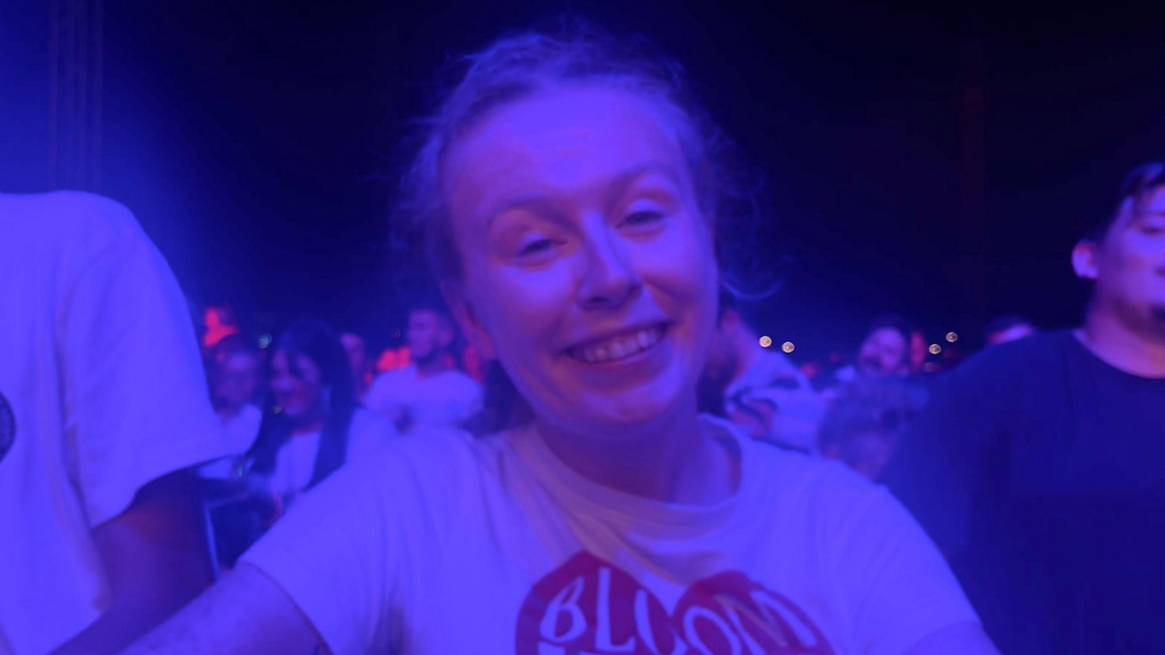 Connie Stephens who is looking at the camera and smiling and is wearing a white T-shirt with a red heart graphic on it. 