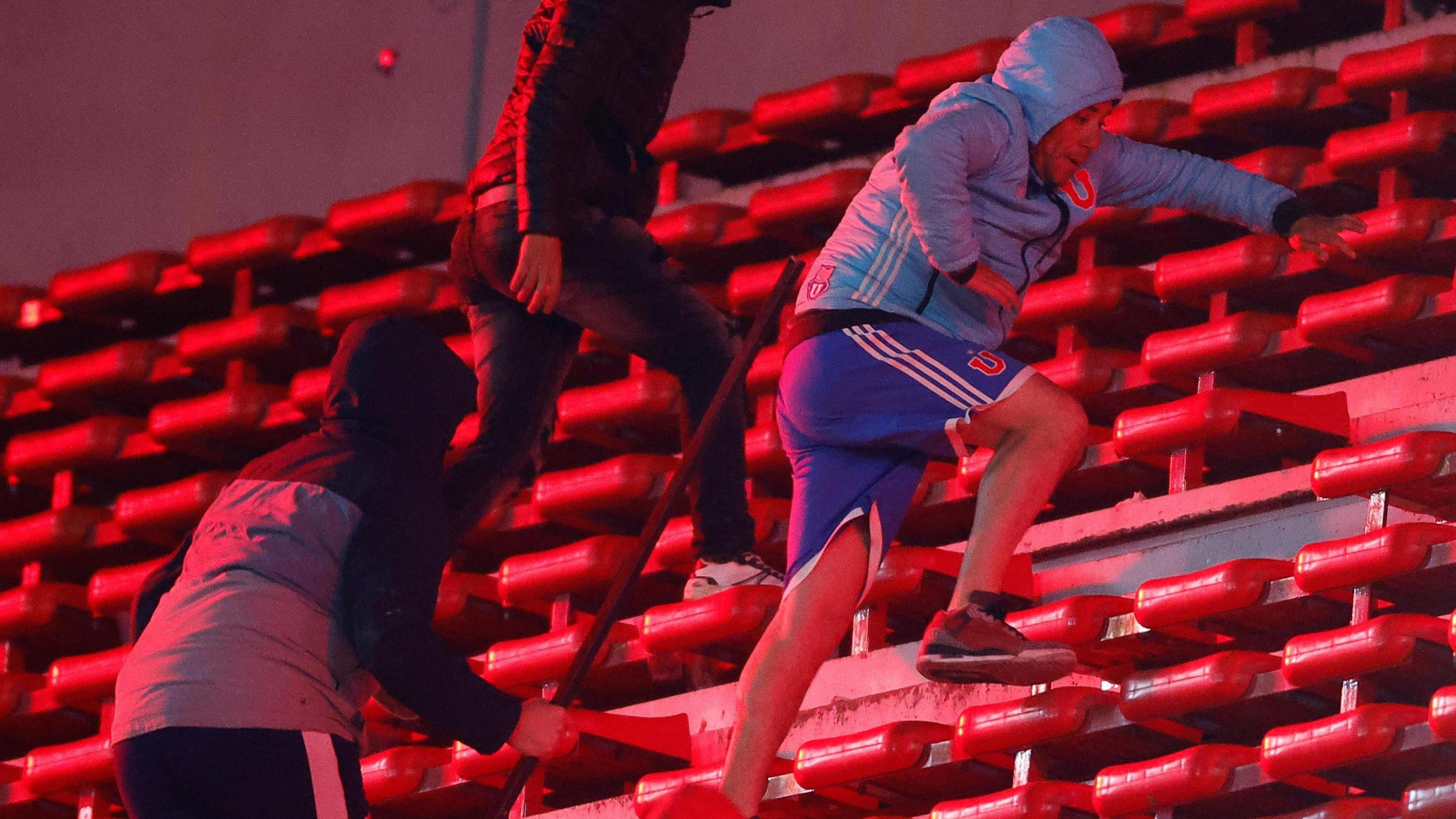 A Universidad de Chile fan being chased by a rival fan at their game away to Independiente in August 2025