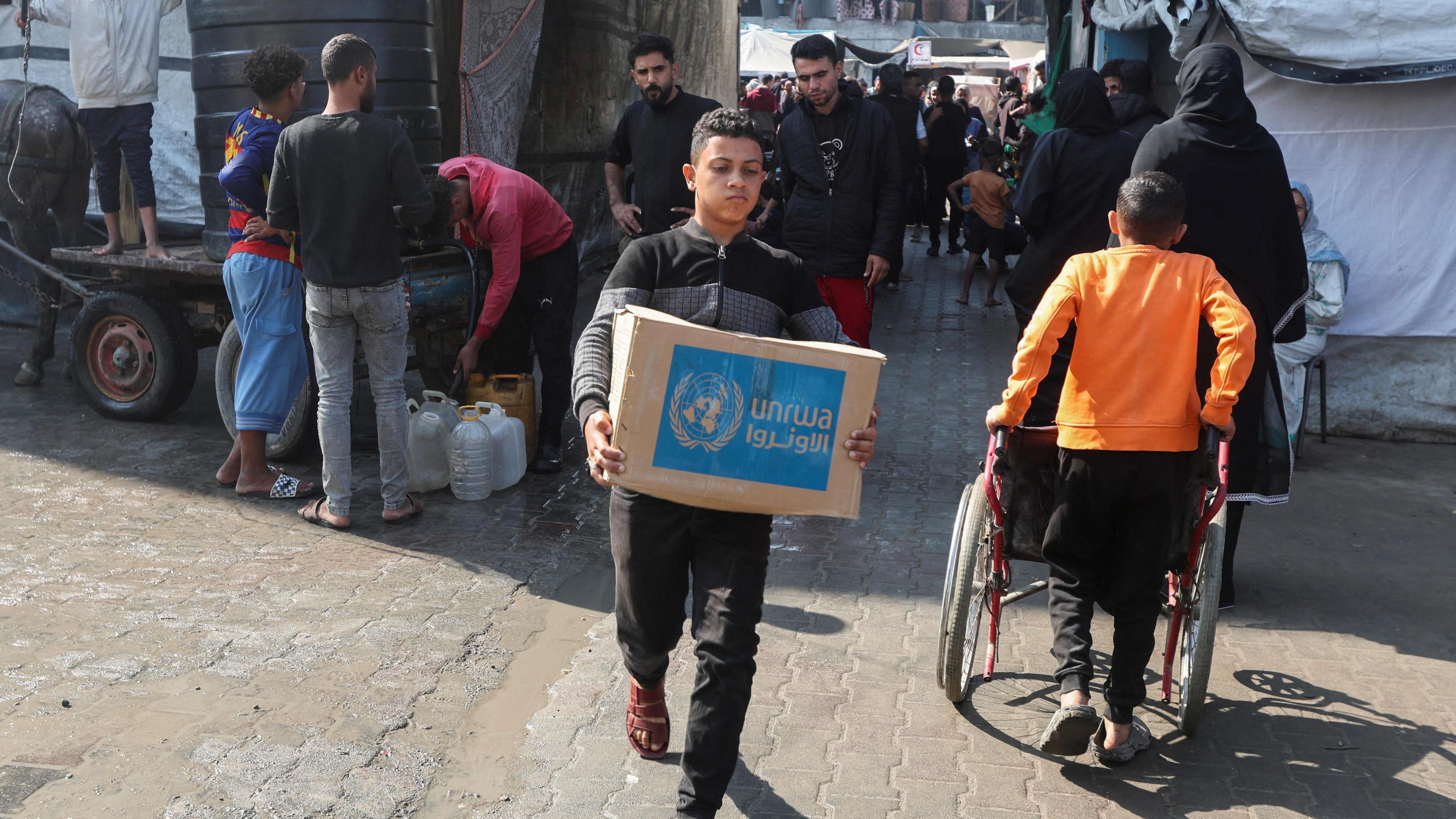 A Palestinian carries an aid box distributed by UNRWA in Deir al-Balah, central Gaza (4 November 2024)