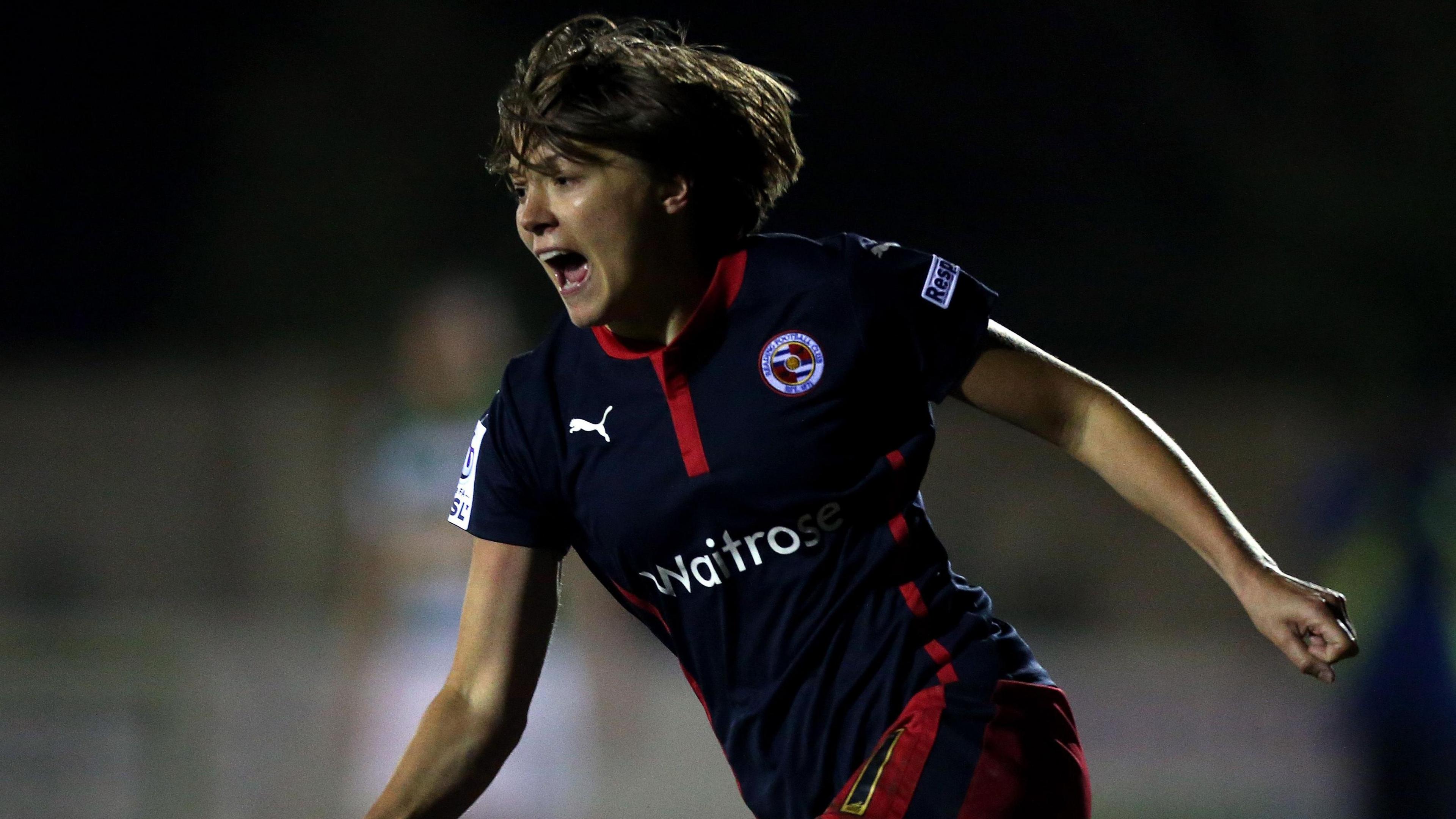 Fran Kirby, wearing a black Reading away shirt, wheels away to celebrate a goal 