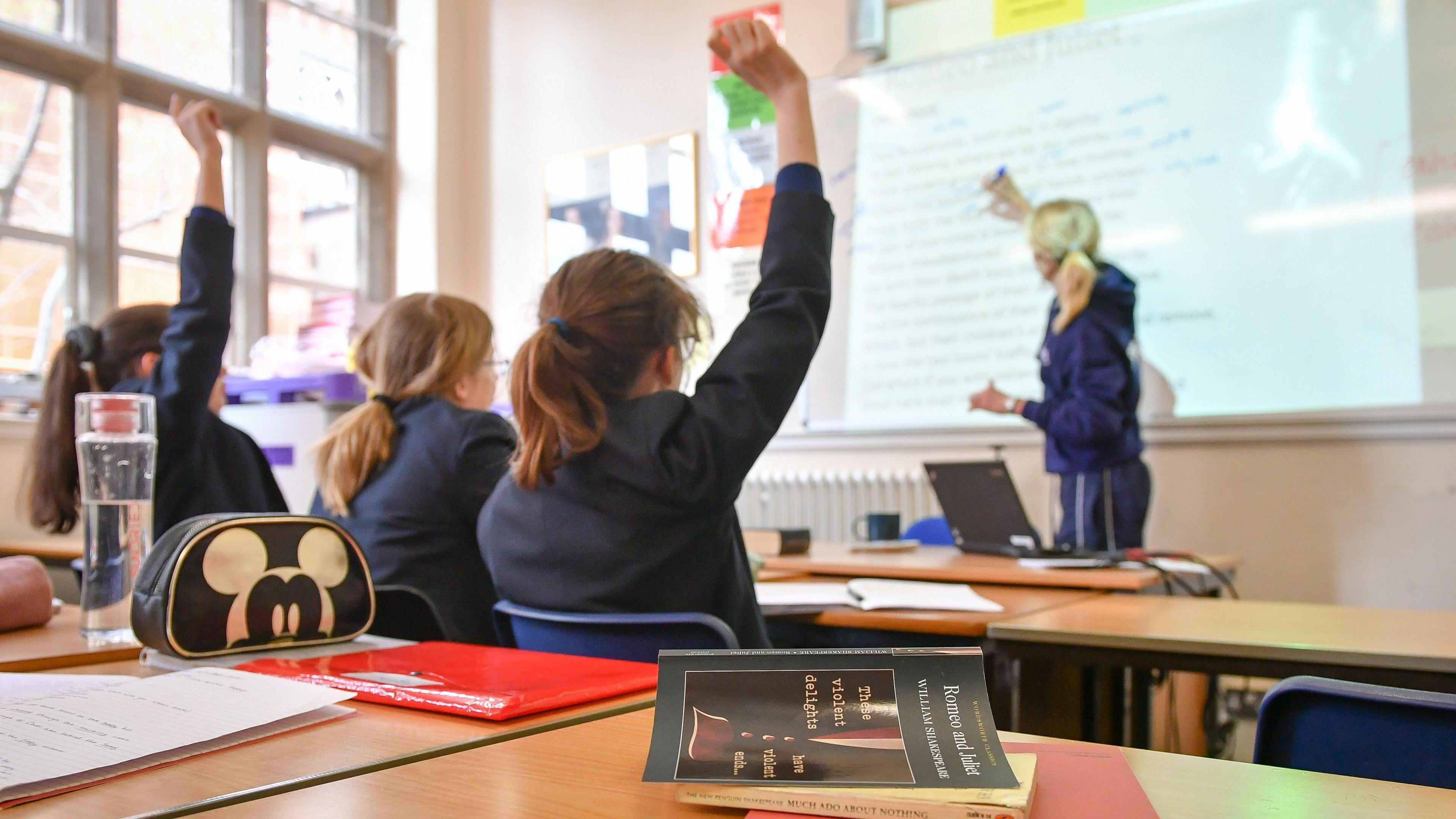 Secondary school pupil raises their hand