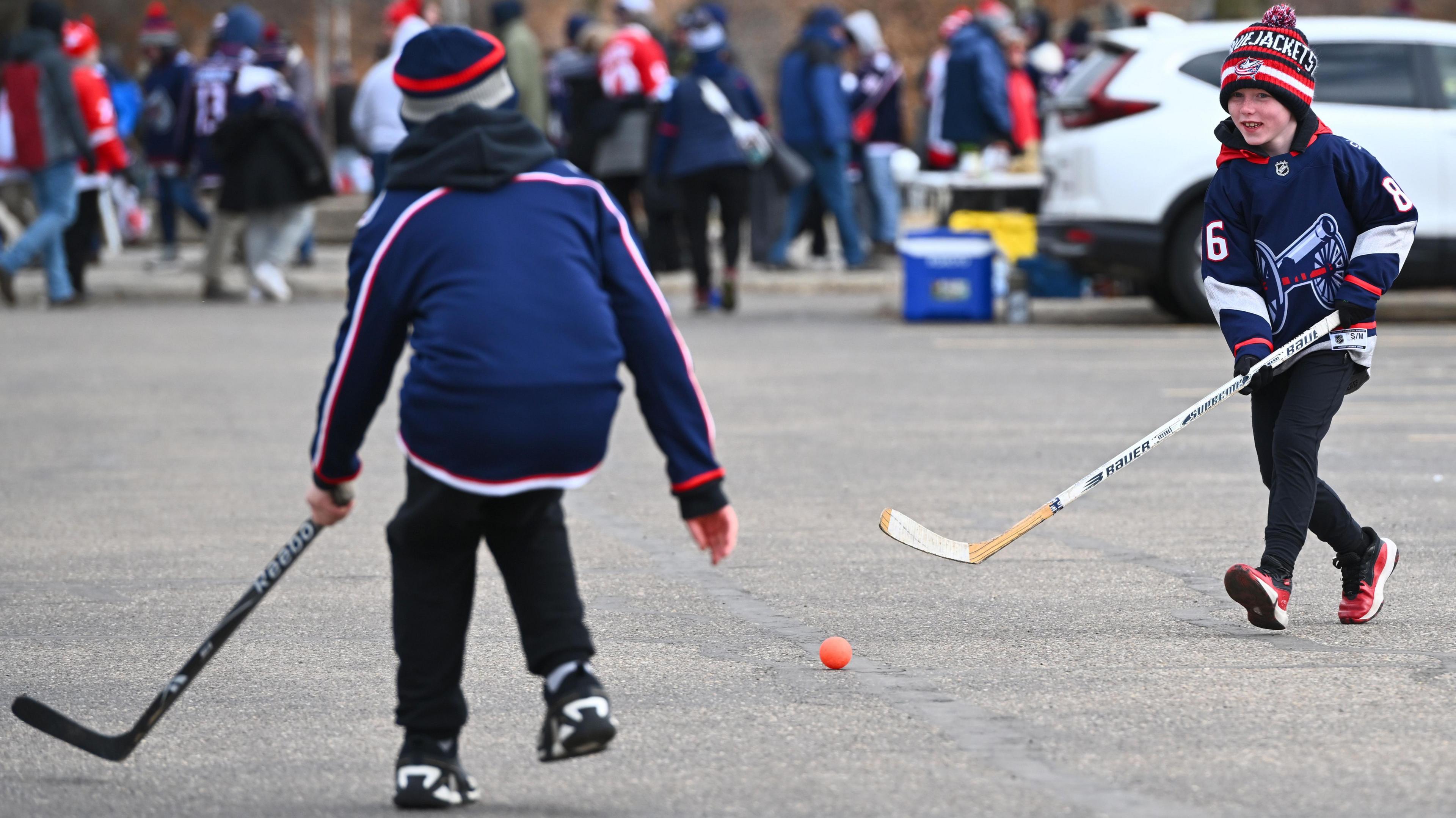 Fans play ball hockey in the parking lot before the NHL Stadium Series game between the Detroit Red Wings and the Columbus Blue Jackets at Ohio