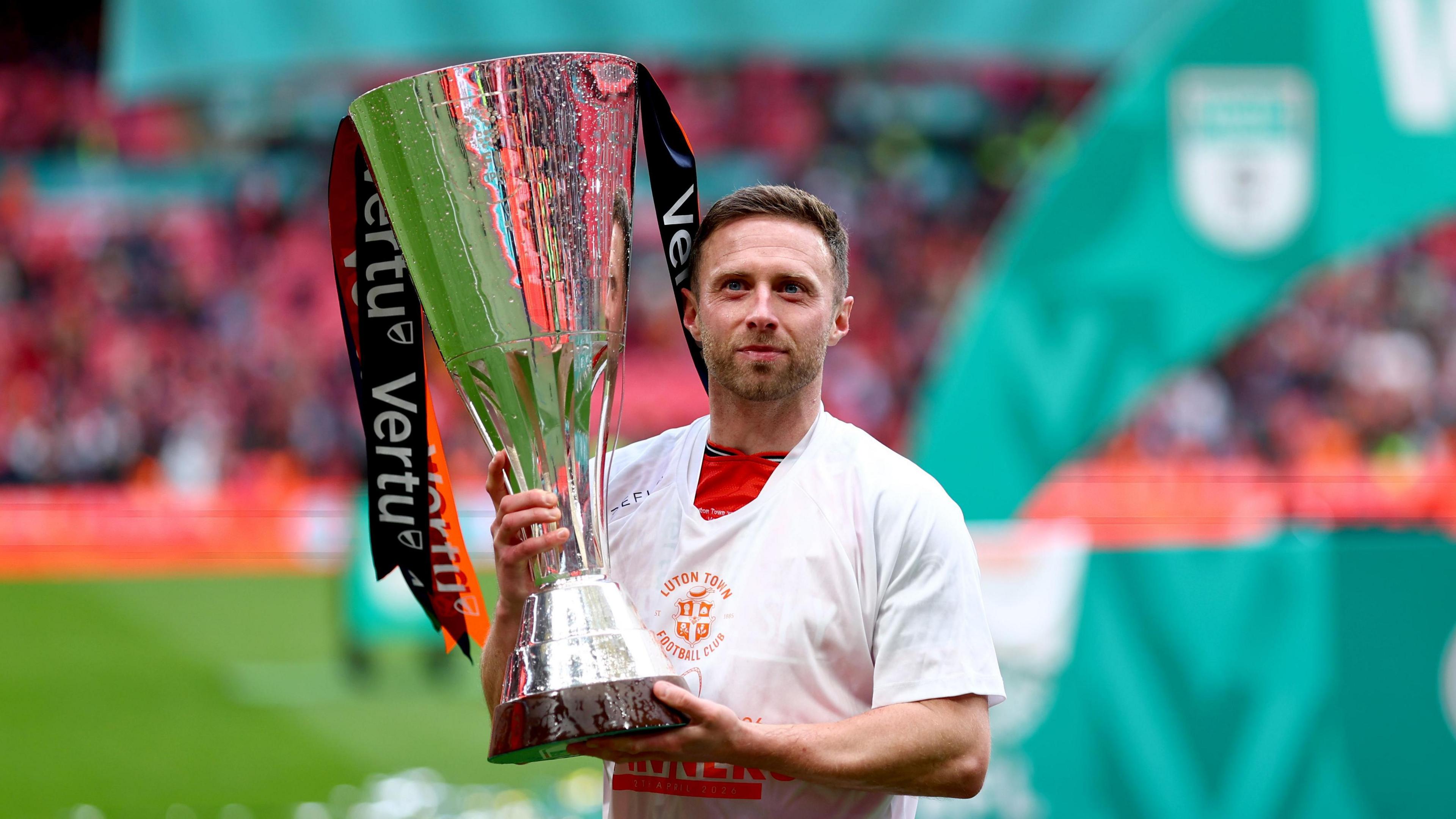 Luton Town midfielder Jordan Clark holding the Vertu Trophy after his side's victory at Wembley Stadium.