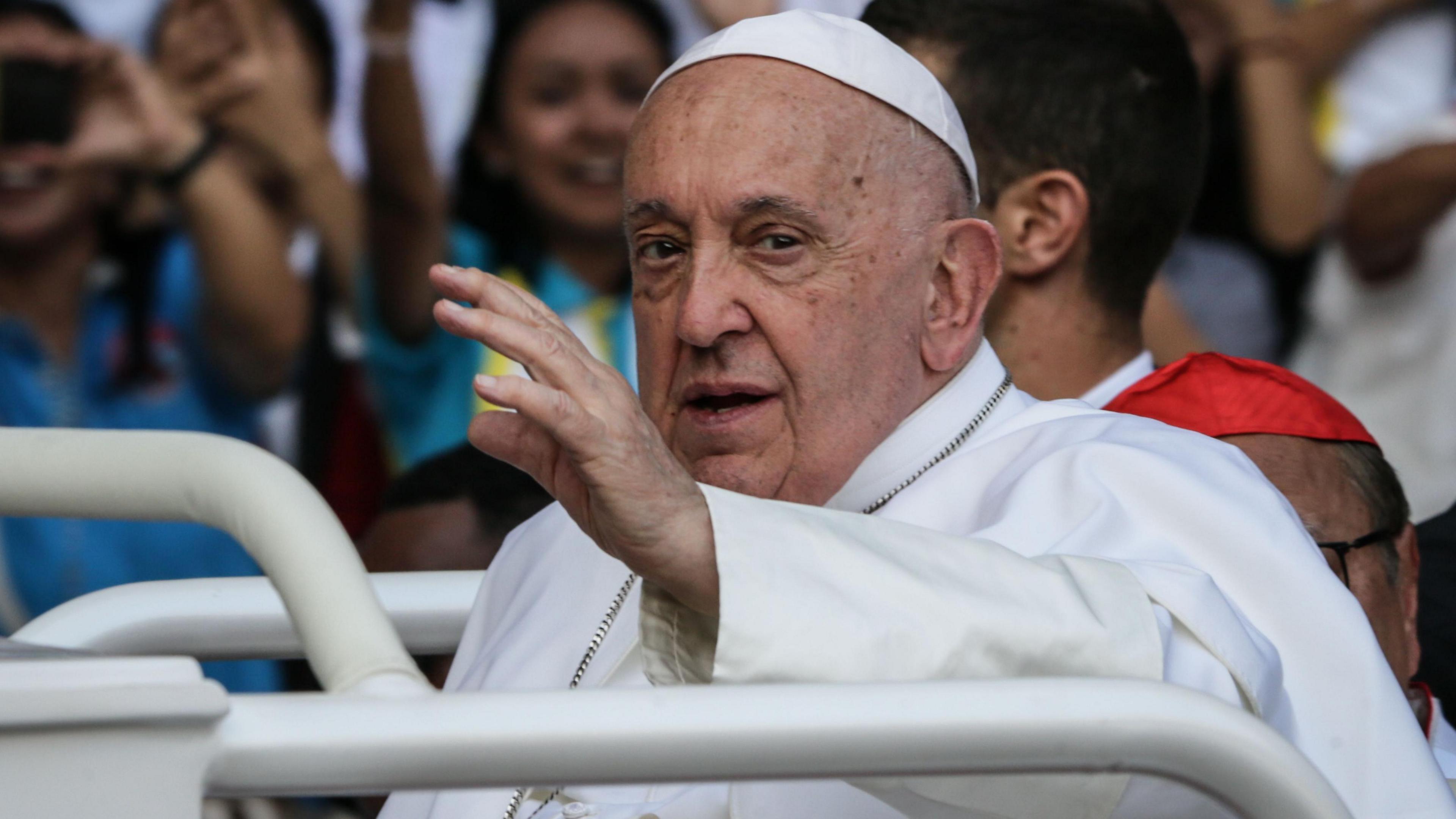 Pope Francis waves to the faithful as he arrives to lead a holy mass in Jakarta, Indonesia.