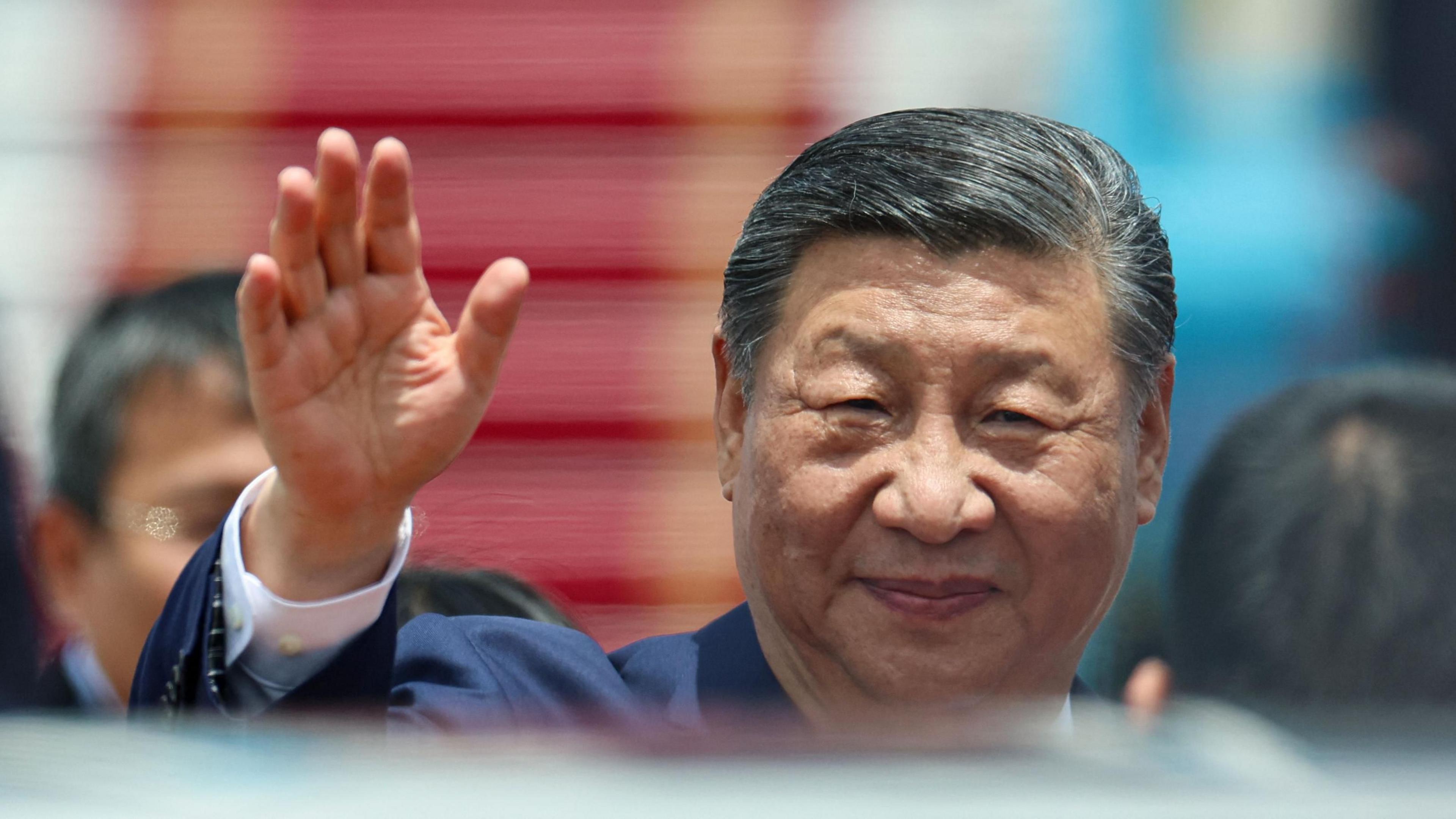Chinese President Xi Jinping waves as he arrives for a two-day state visit at Hanoi's Noi Bai International Airport on April 14, 2025. 