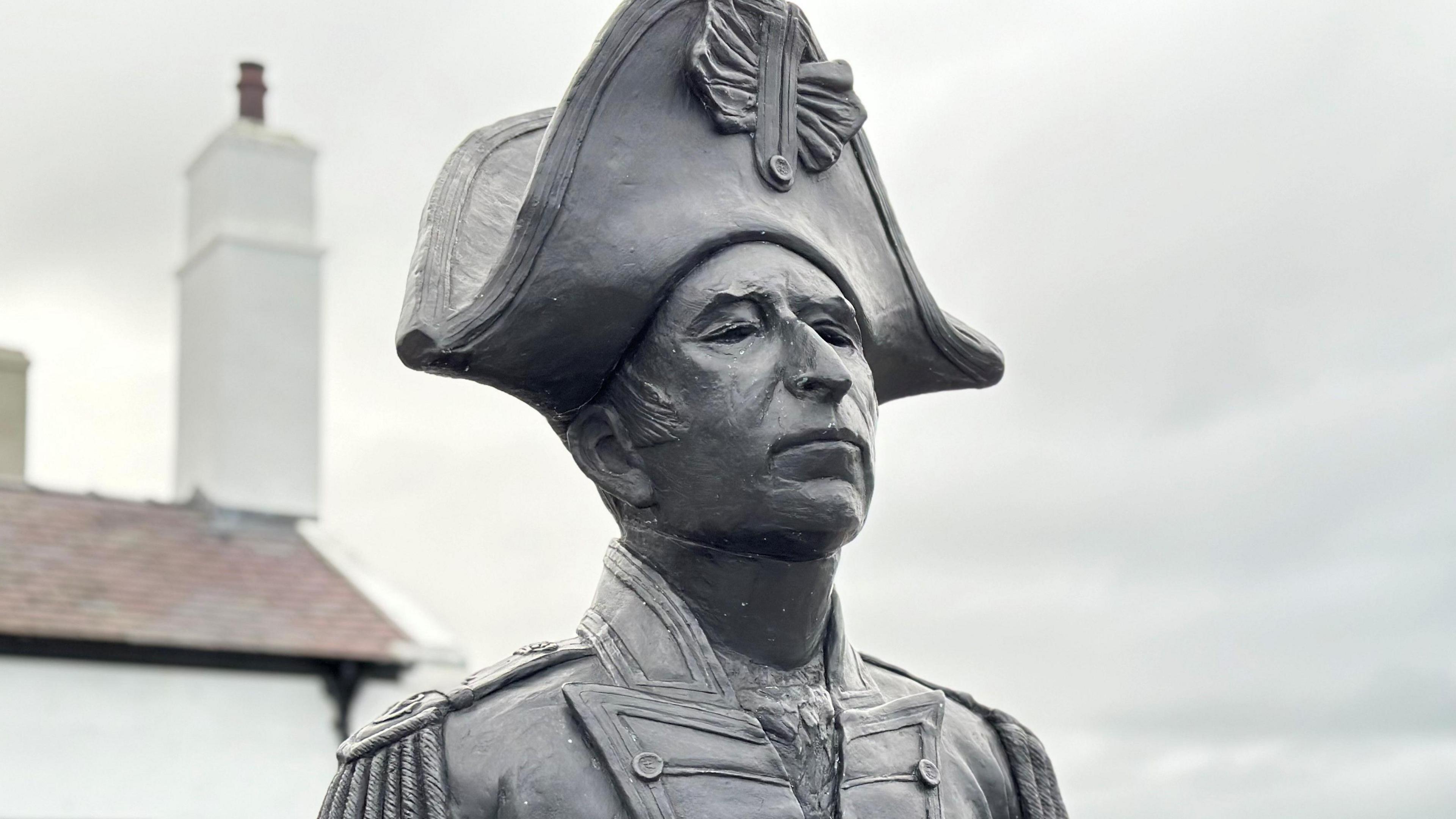 A bust of John Quilliam, who is wearing naval uniform from the time of the Battle of Trafalgar. 