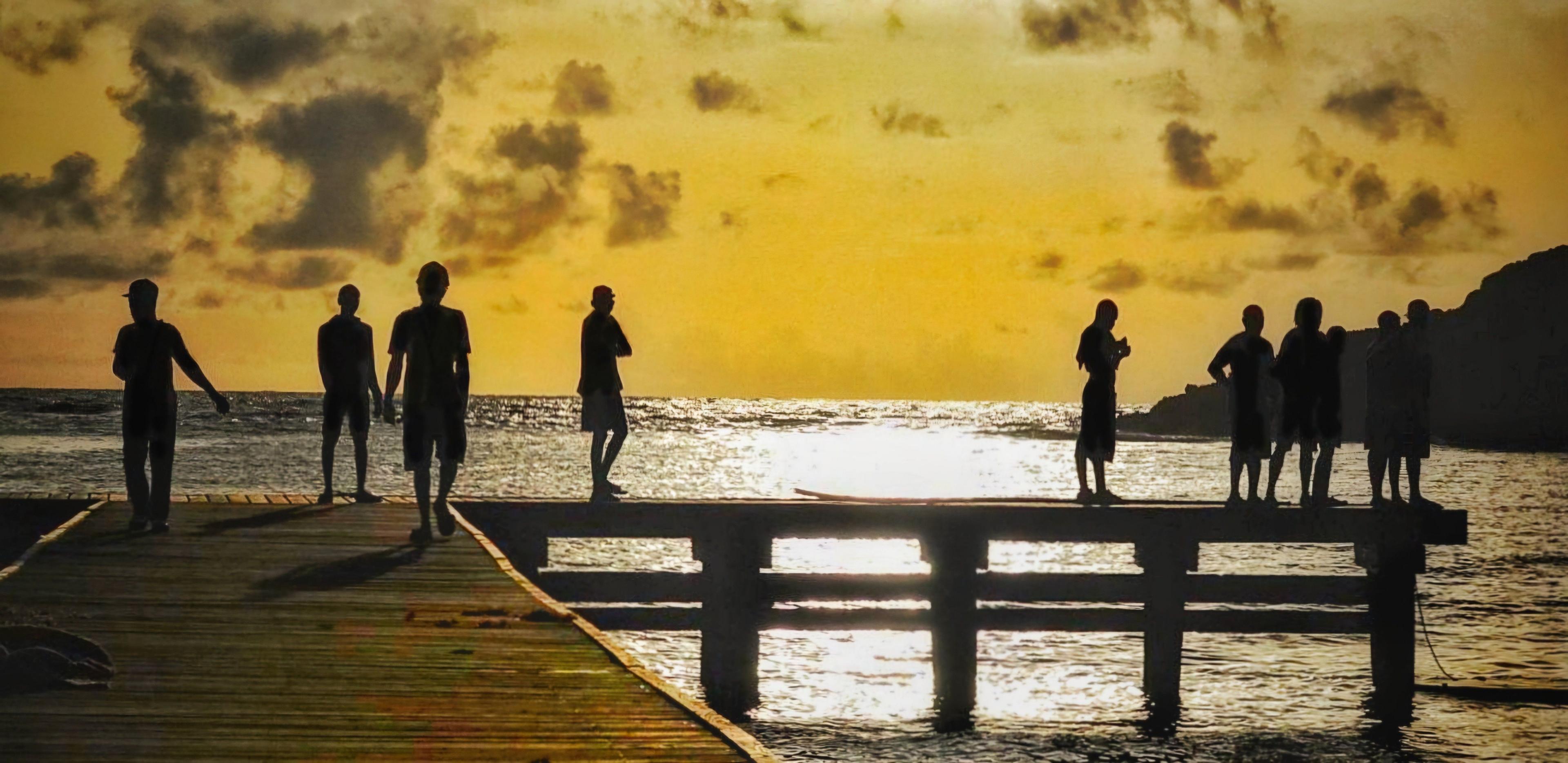 Figures silhouetted on a jetty