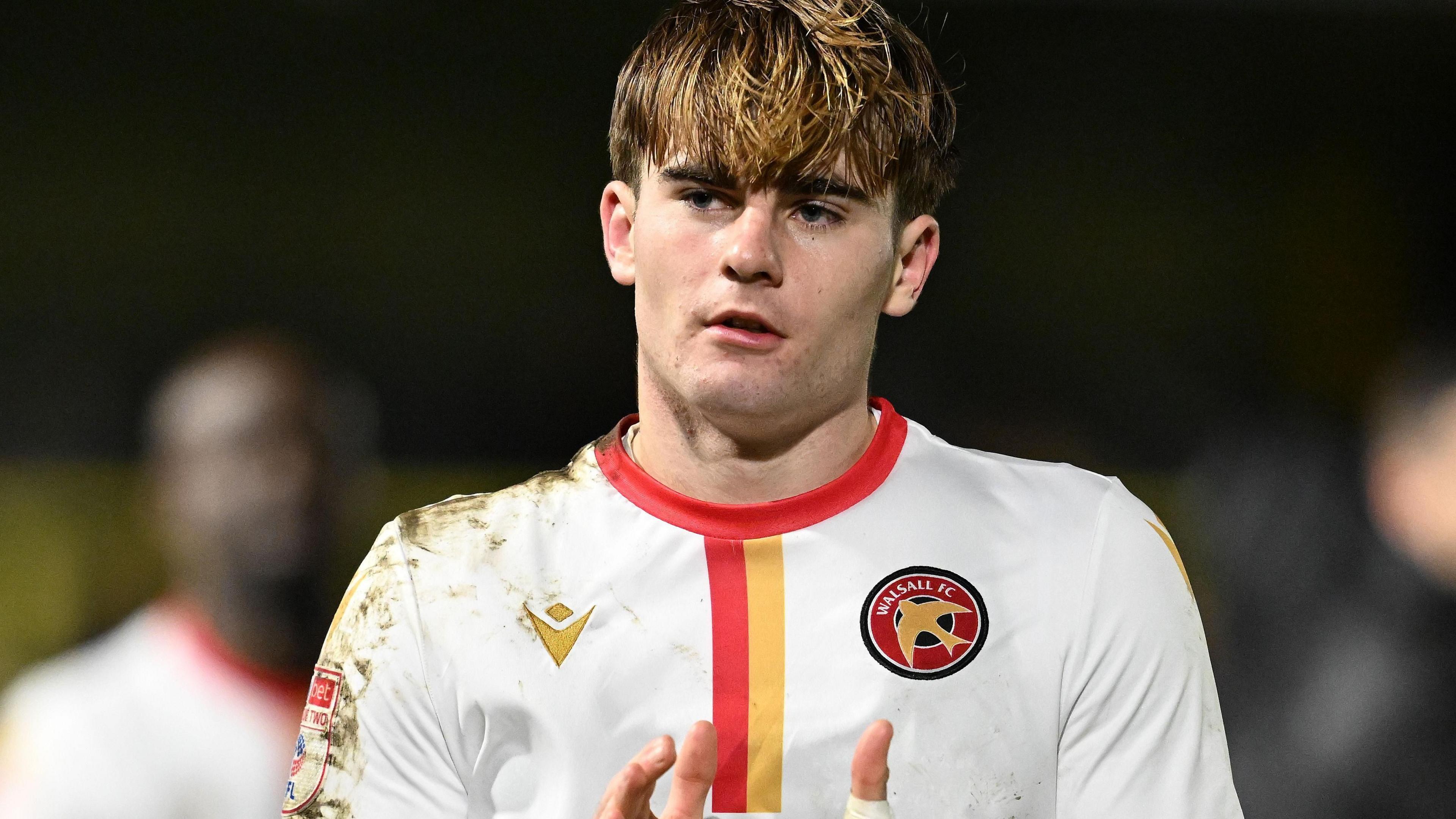 Walsall's 19-year-old striker Nathan Lowe in their third kit, a white shirt with red and yellow trim