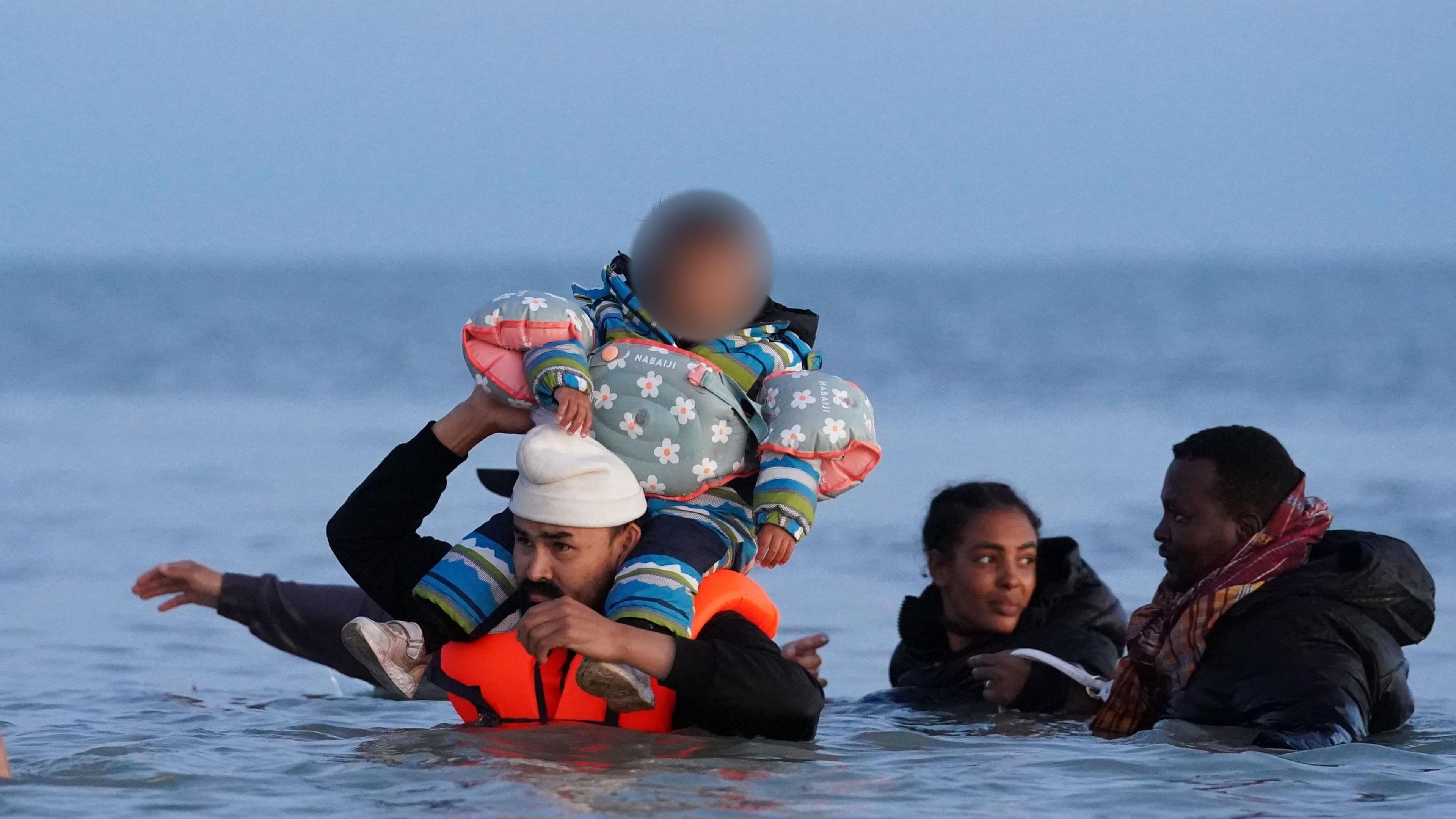 A group of people thought to be migrants wade into the sea in Gravelines, France, on 19 September 2025