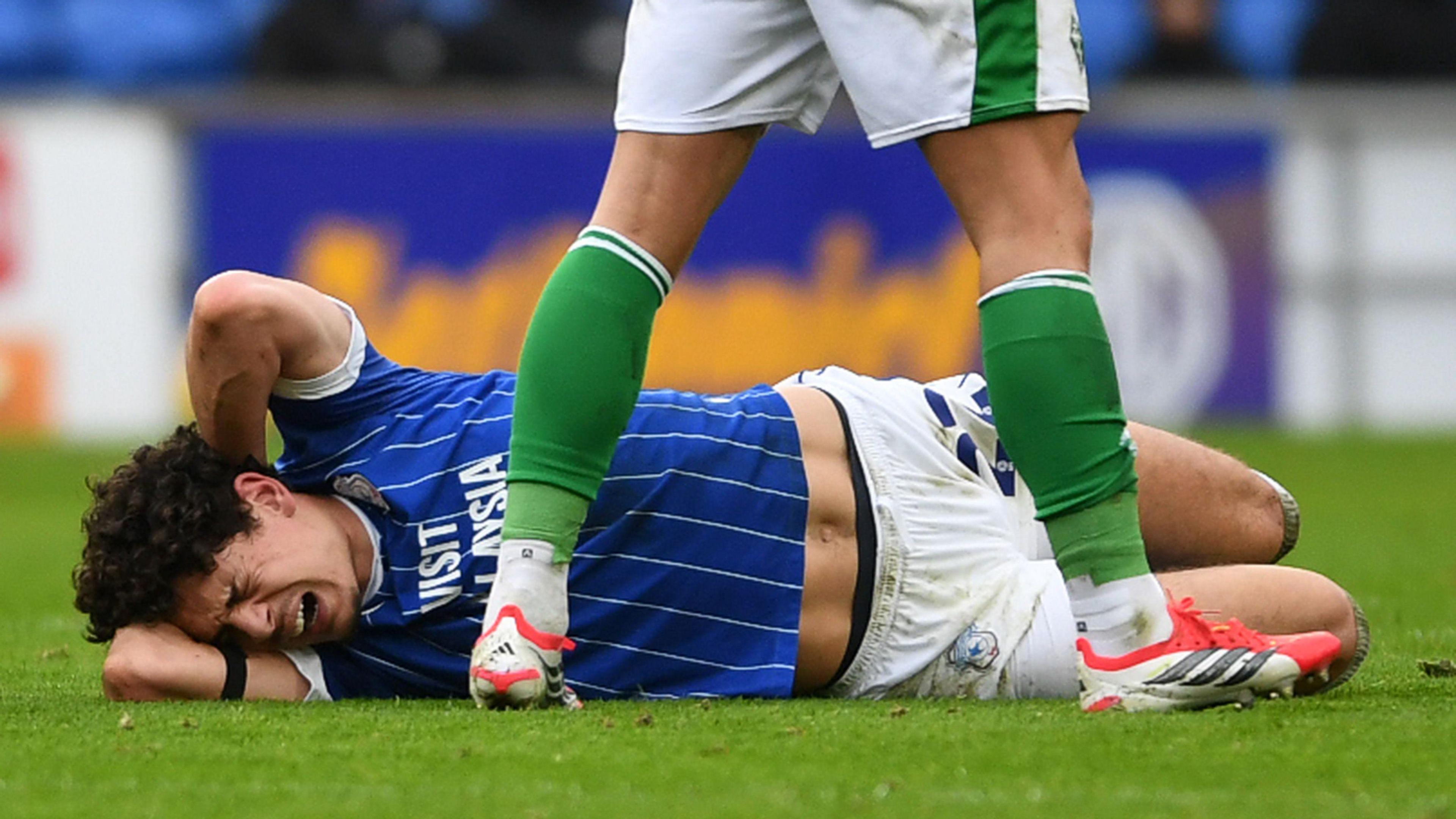 Yousuf Salech lies on the ground in pain holding his head