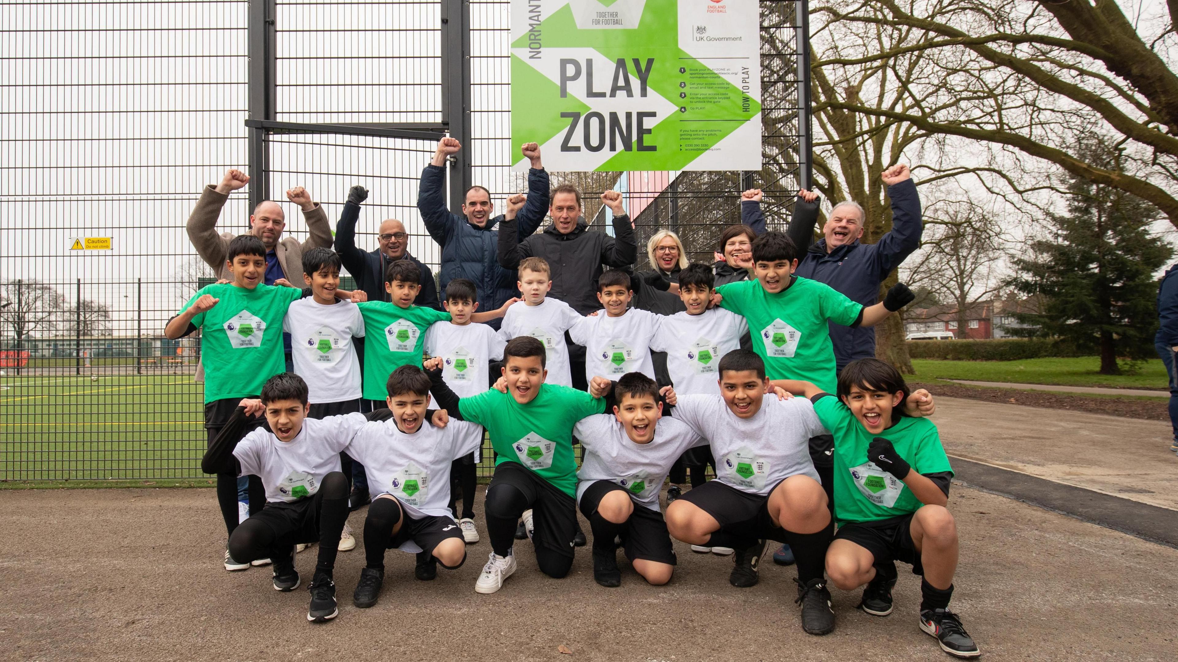 Pupils from Dale Community Primary school with other representatives from Derby City Council, the Football Foundation and the Premier League cheering in front of new court