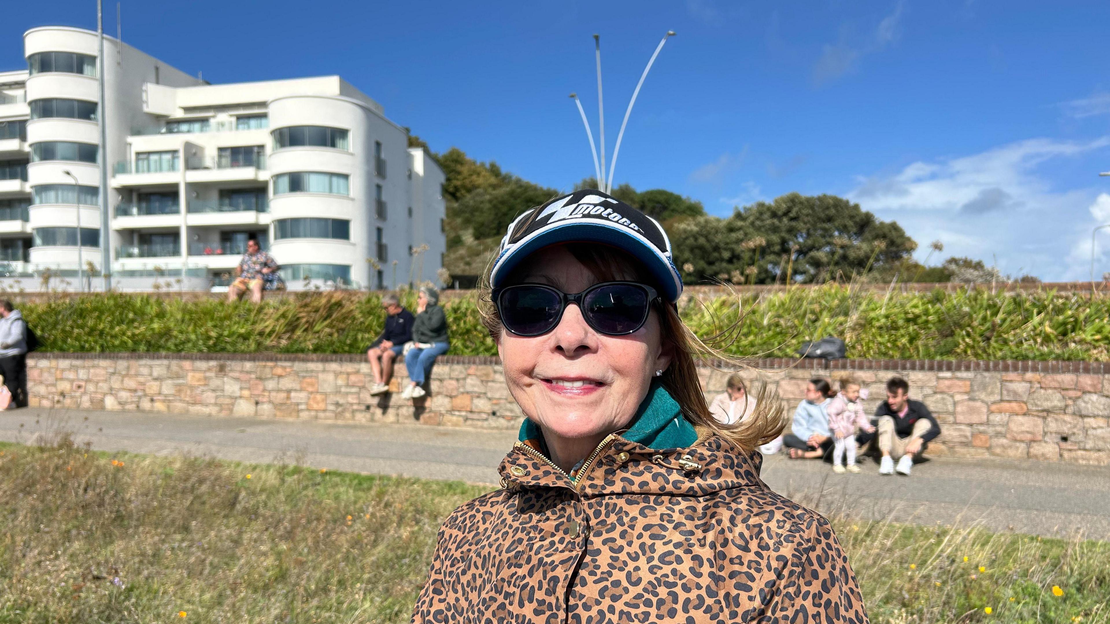 A woman in sunglasses and a cap with some fake antenna.