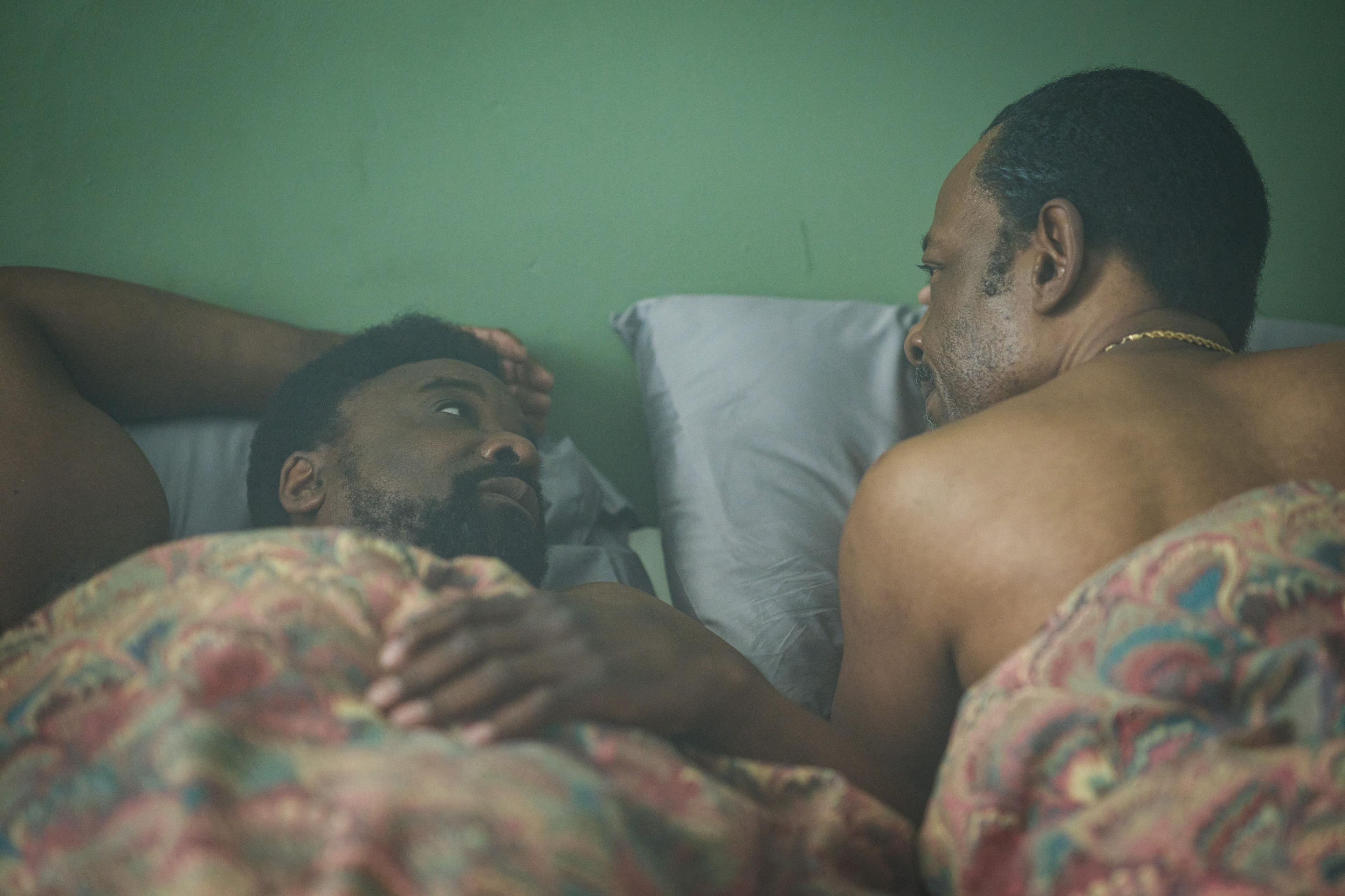 Morris De La Roux, played by Ariyon Bakare and Barry Walker, played by Lennie James, lying in bed looking at one another