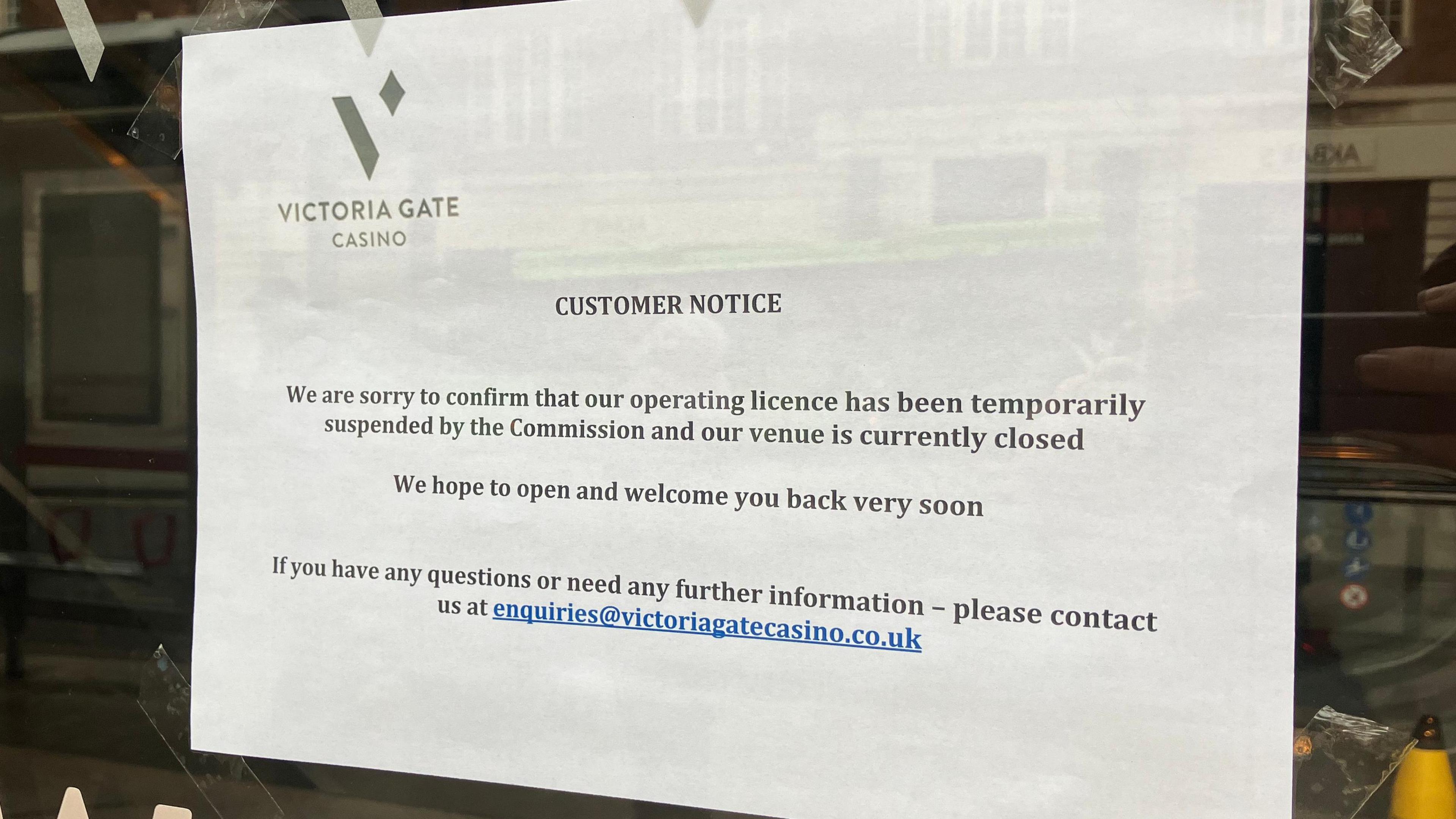 Printed notice taped to a glass door at Victoria Gate Casino. The notice states that the casino’s operating licence has been temporarily suspended by the Commission and the venue is currently closed.