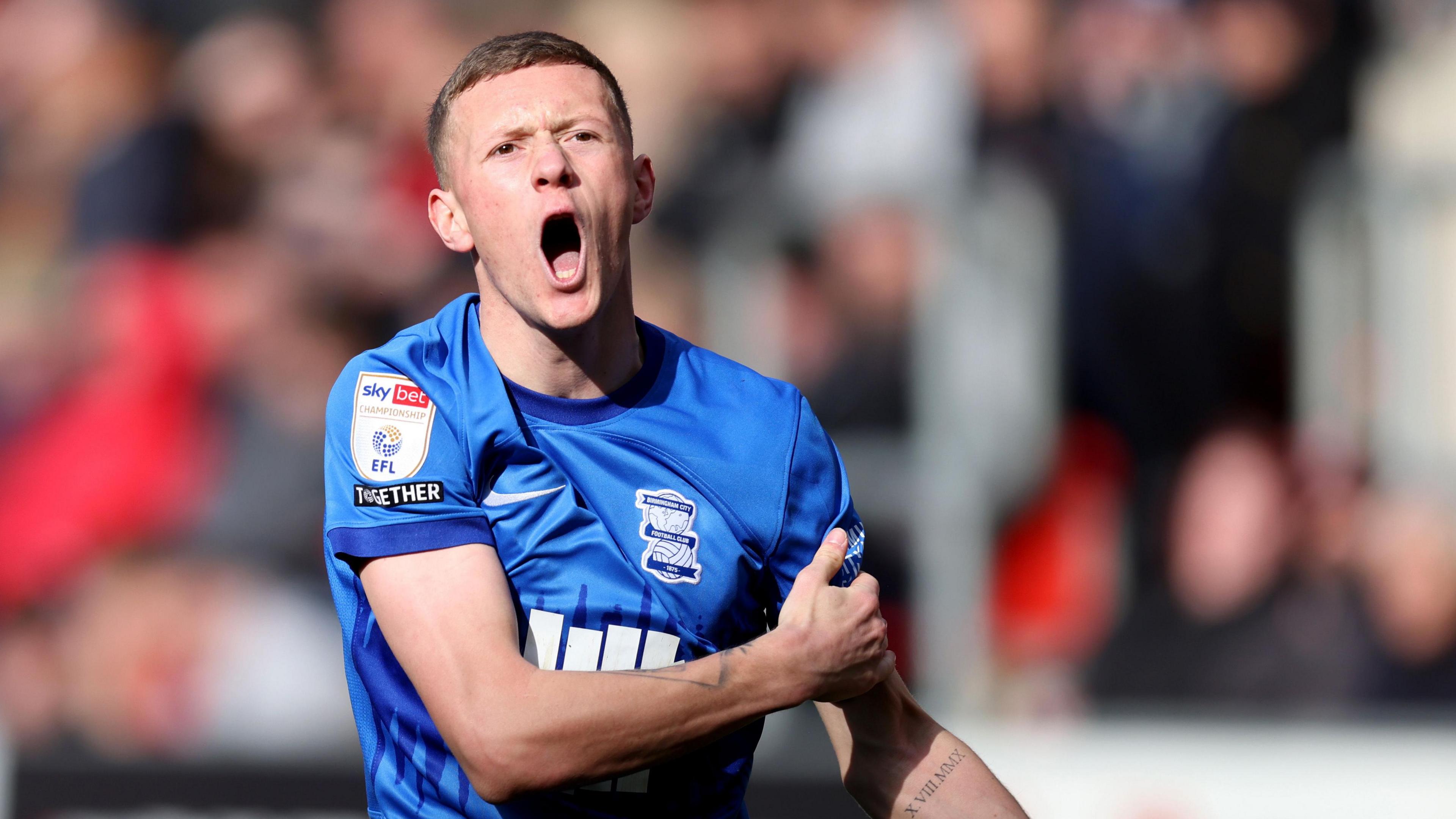 Jay Stansfield, wearing Birmingham's home kit in a game against Rotherham, shouts to an off camera team-mate 