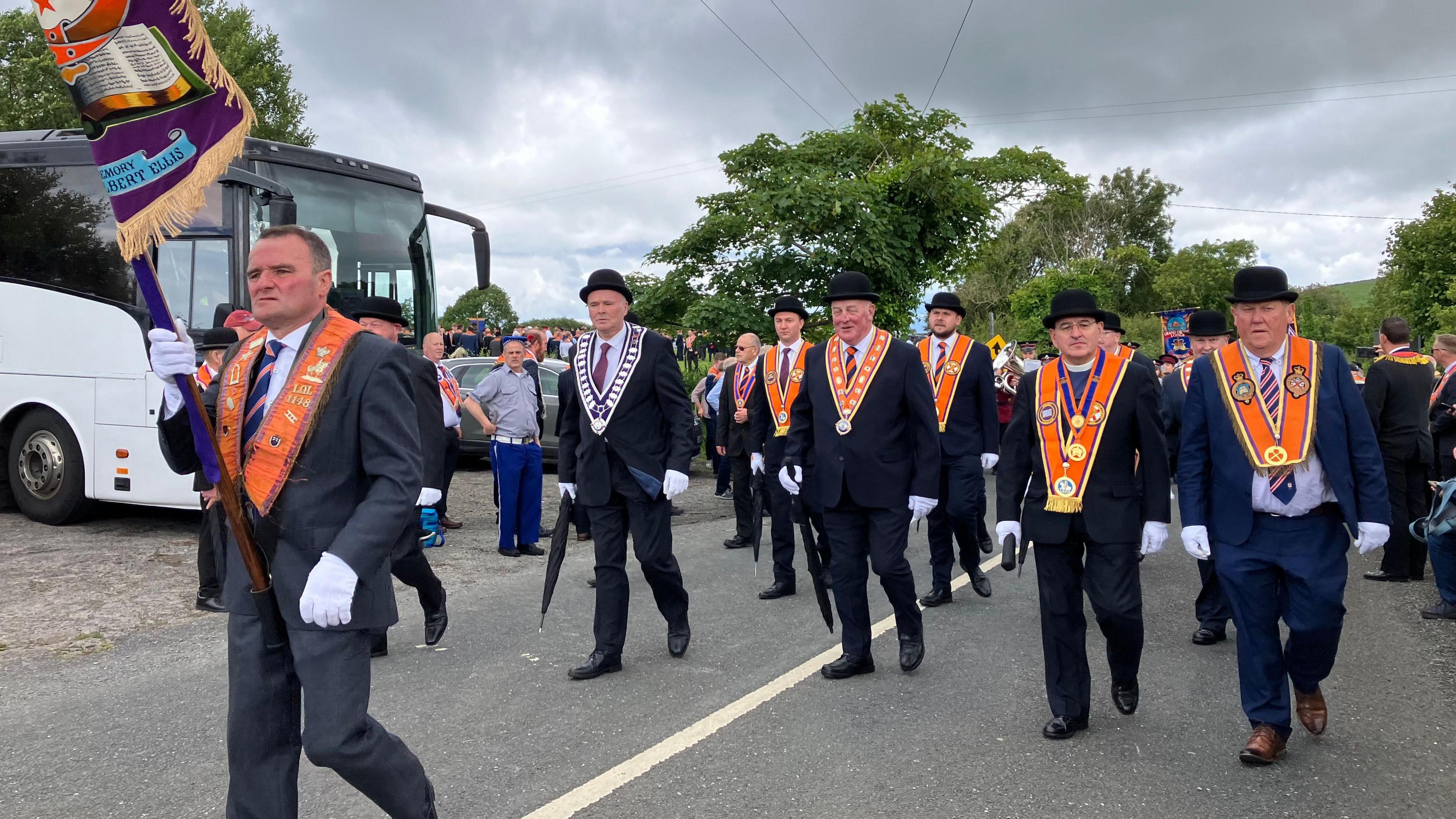 Members of the Orange Order march along a country road