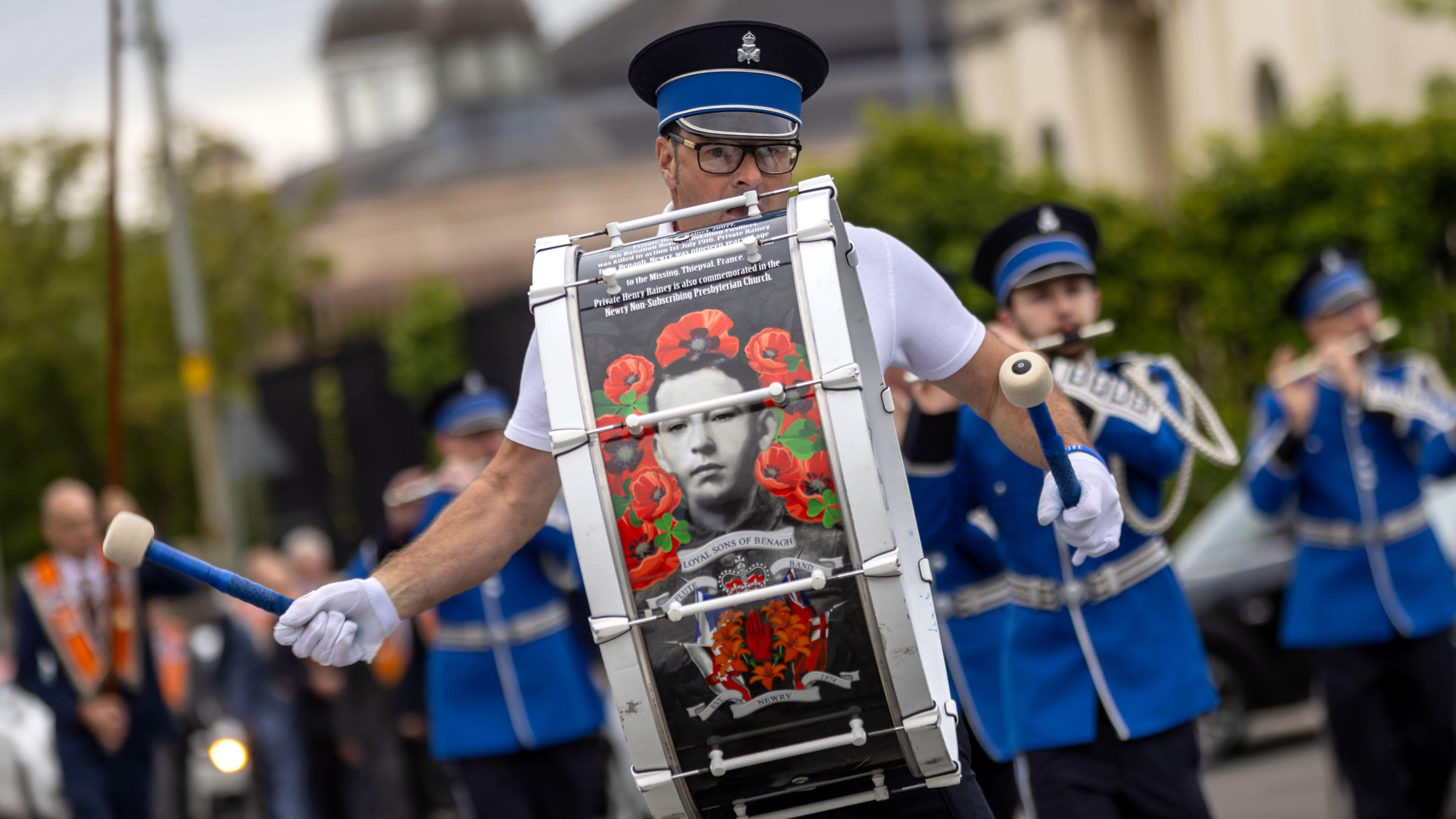 A man bangs a drum during the parade 