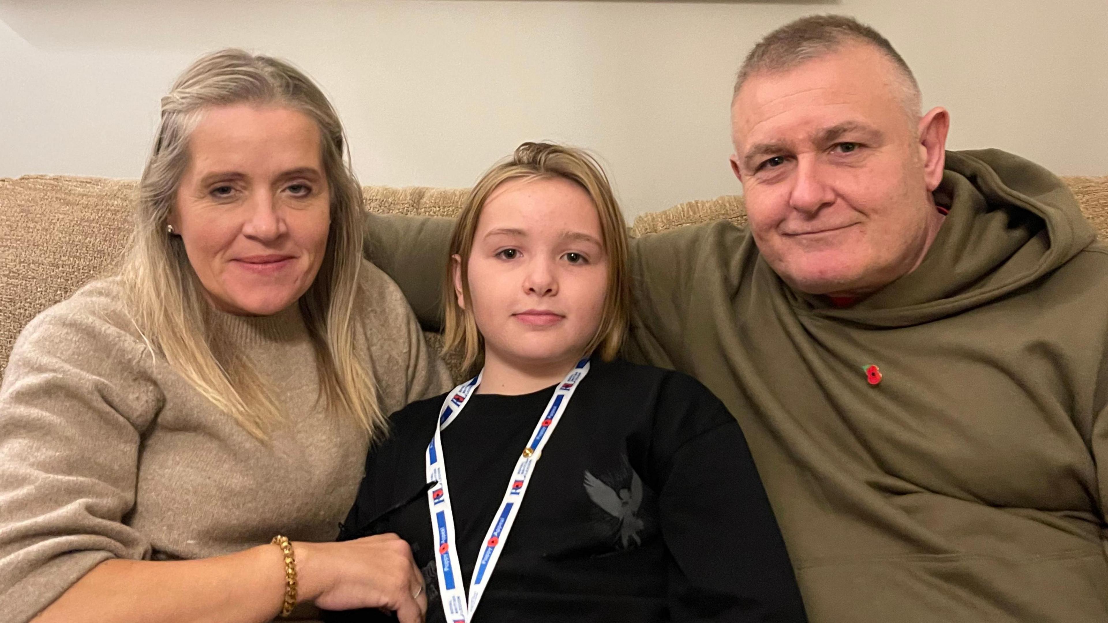 A woman on the left, a child in the middle and a man on the right.