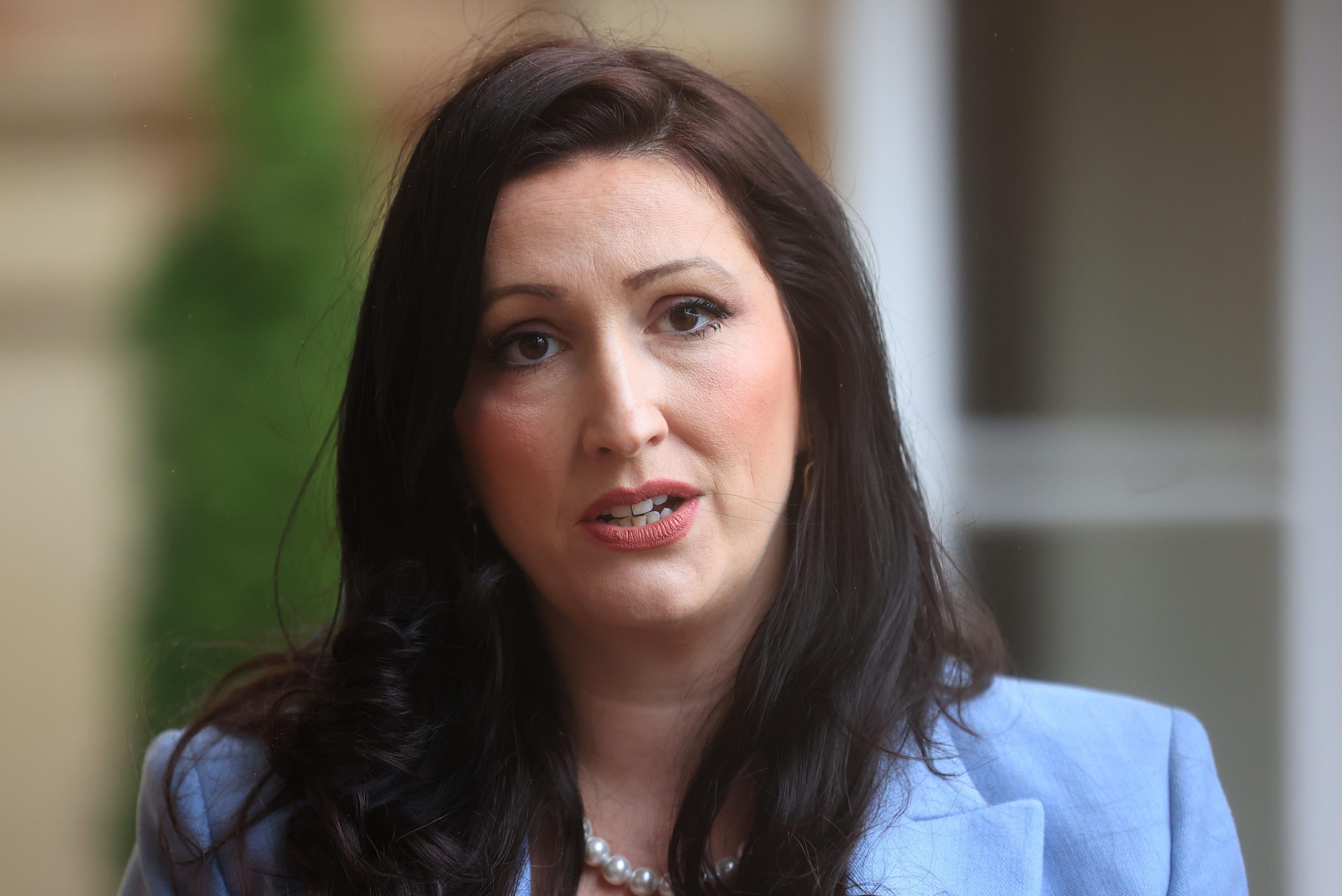 Emma Little-Pengelly who has long dark hair and is wearing a blue jacket