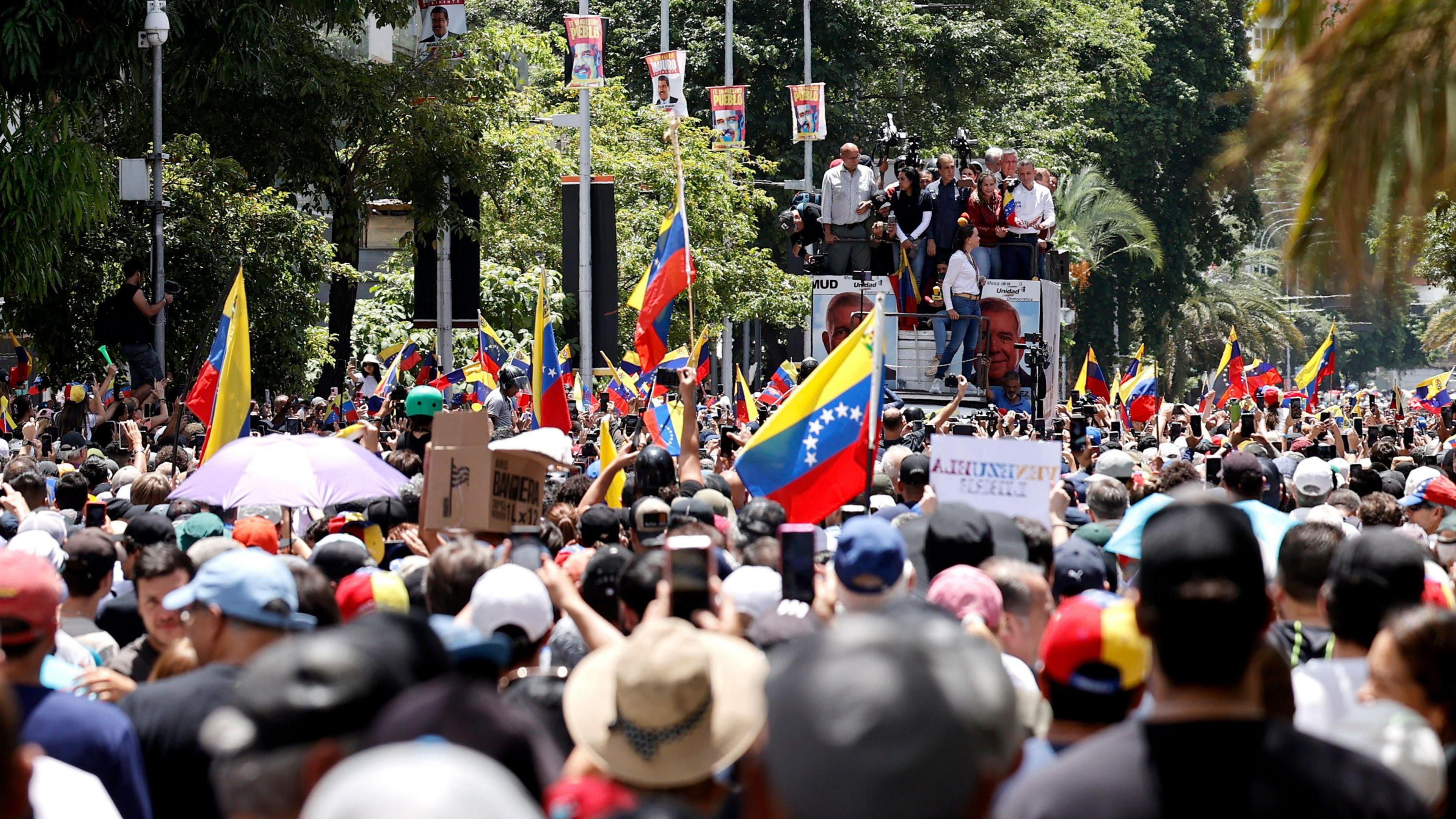 Venezuelan opposition leaders stand on top of a truck amid a crowd of anti-government protesters in Caracas