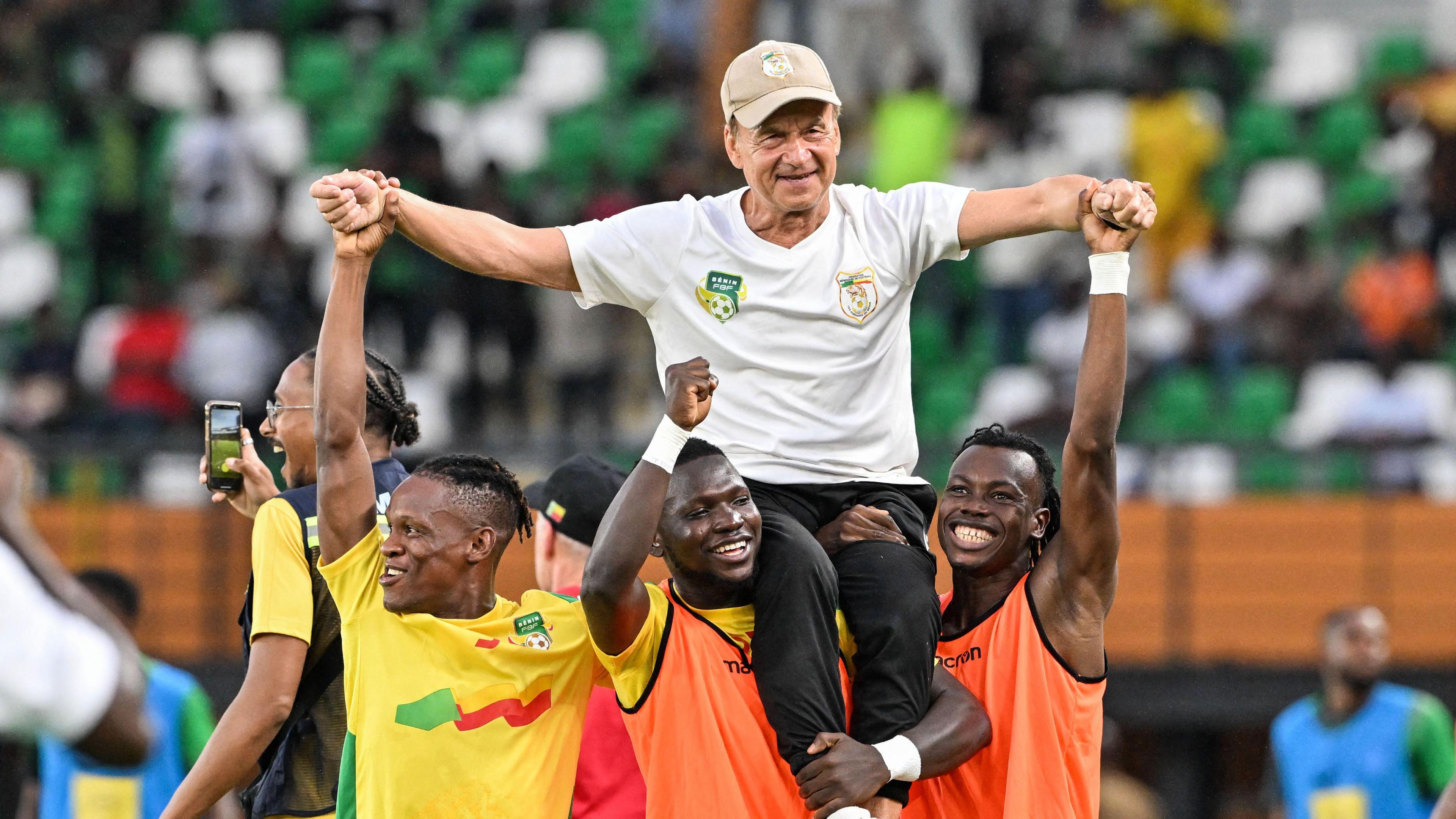 Benin coach Gernot Rohr is chaired onto the pitch by players after his side beat Nigeria