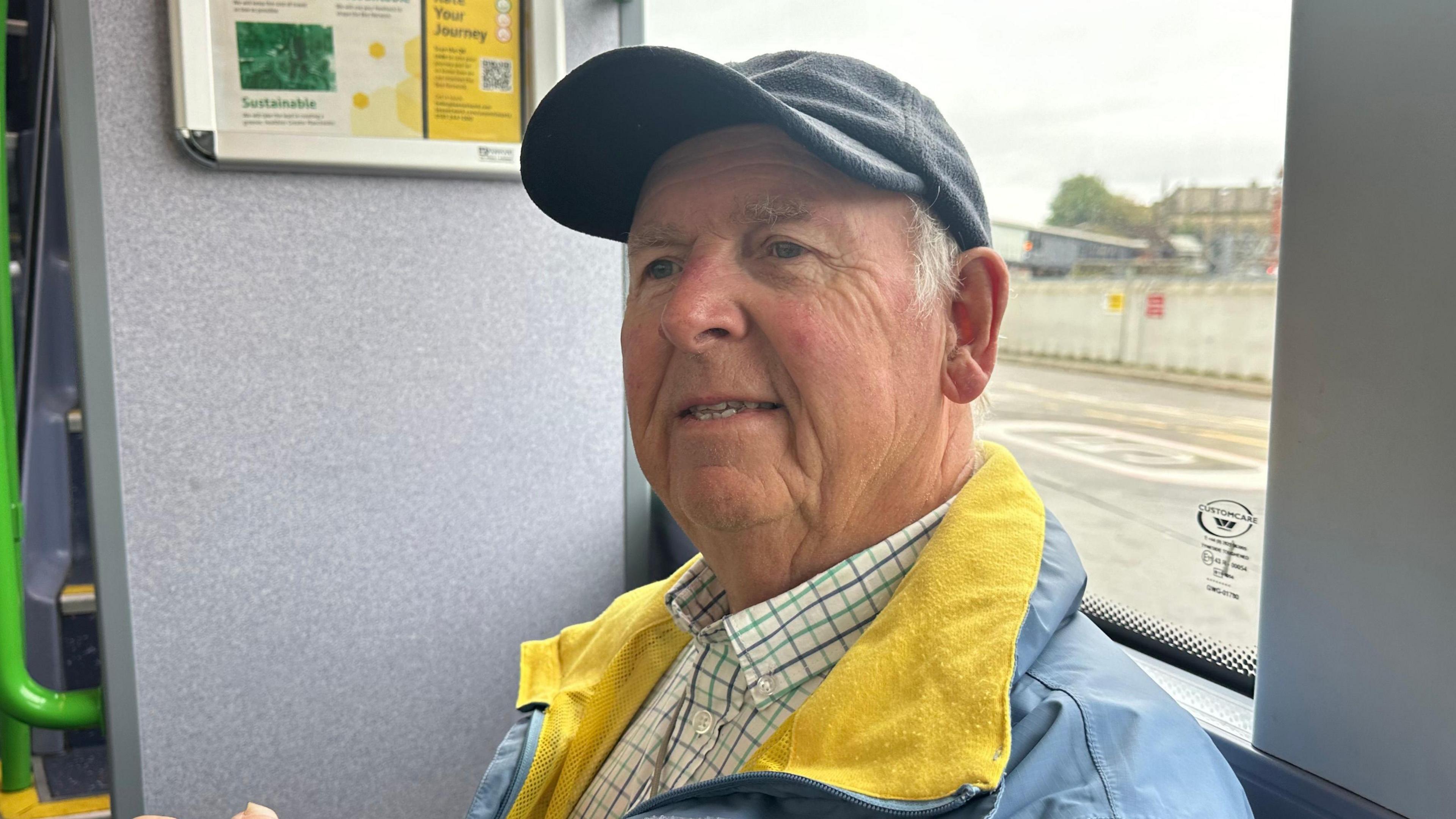 Leslie Downes sat on a Bee Network bus wearing a cap 