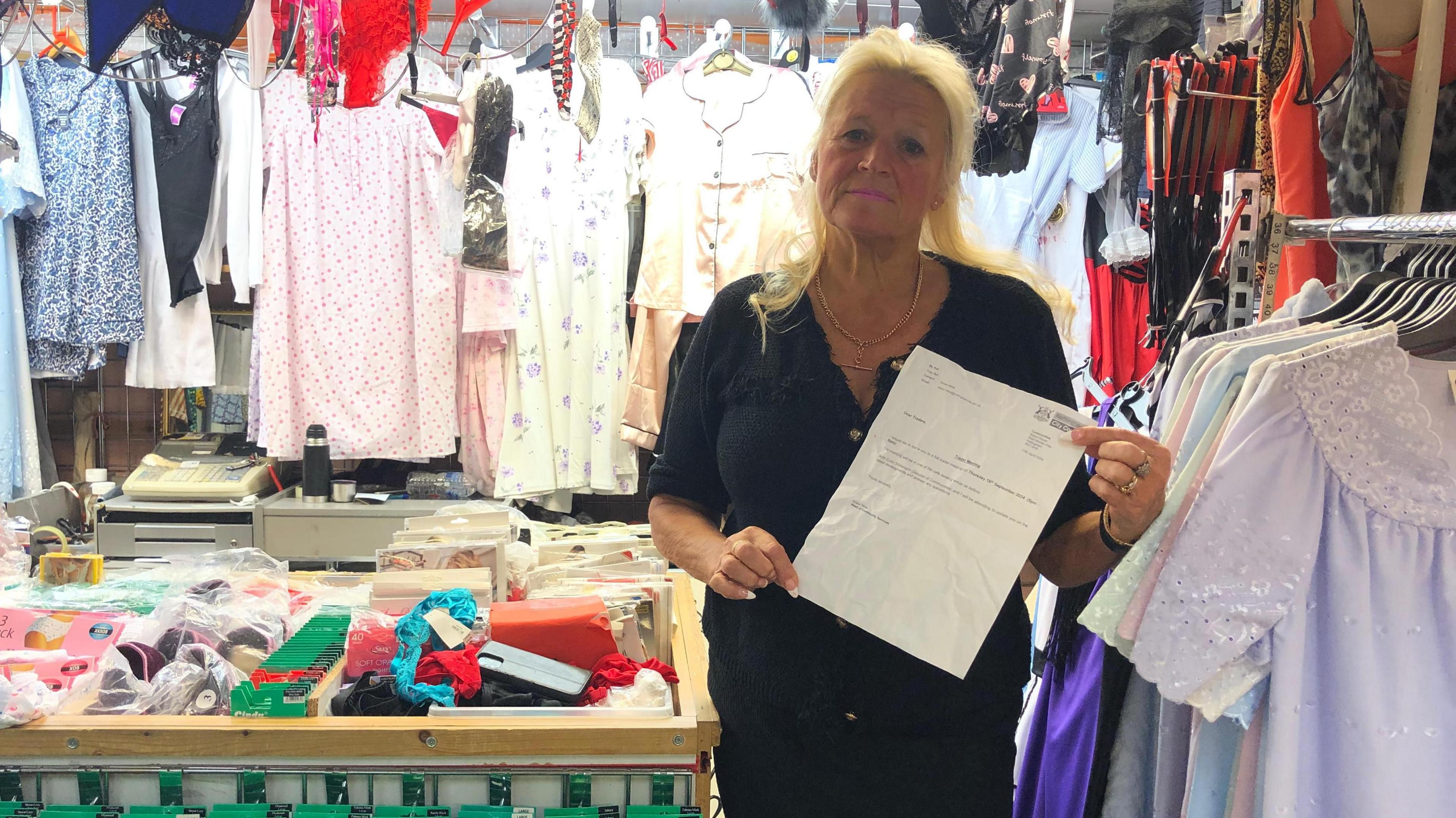 Carole Lilley stood by her stall holding a letter in her hands