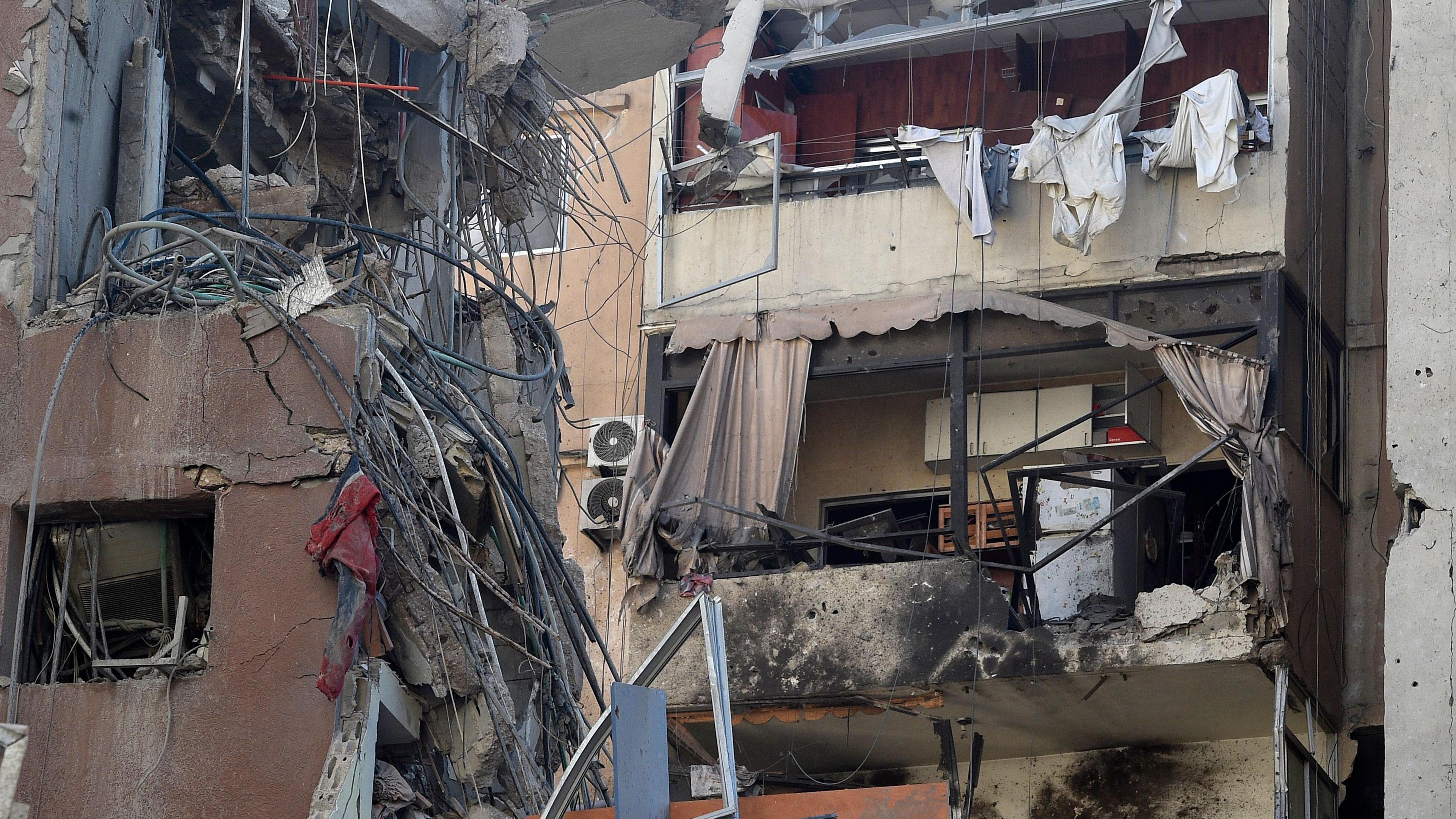 Building destroyed with wires hanging out from debris