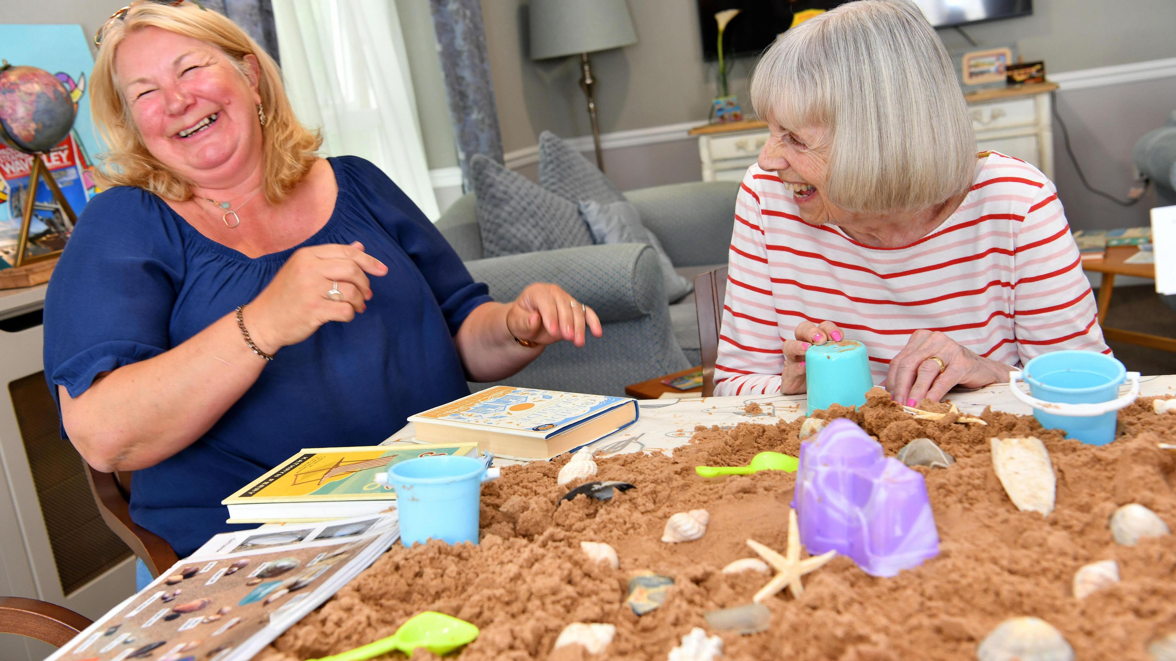 Two women playing with sand 