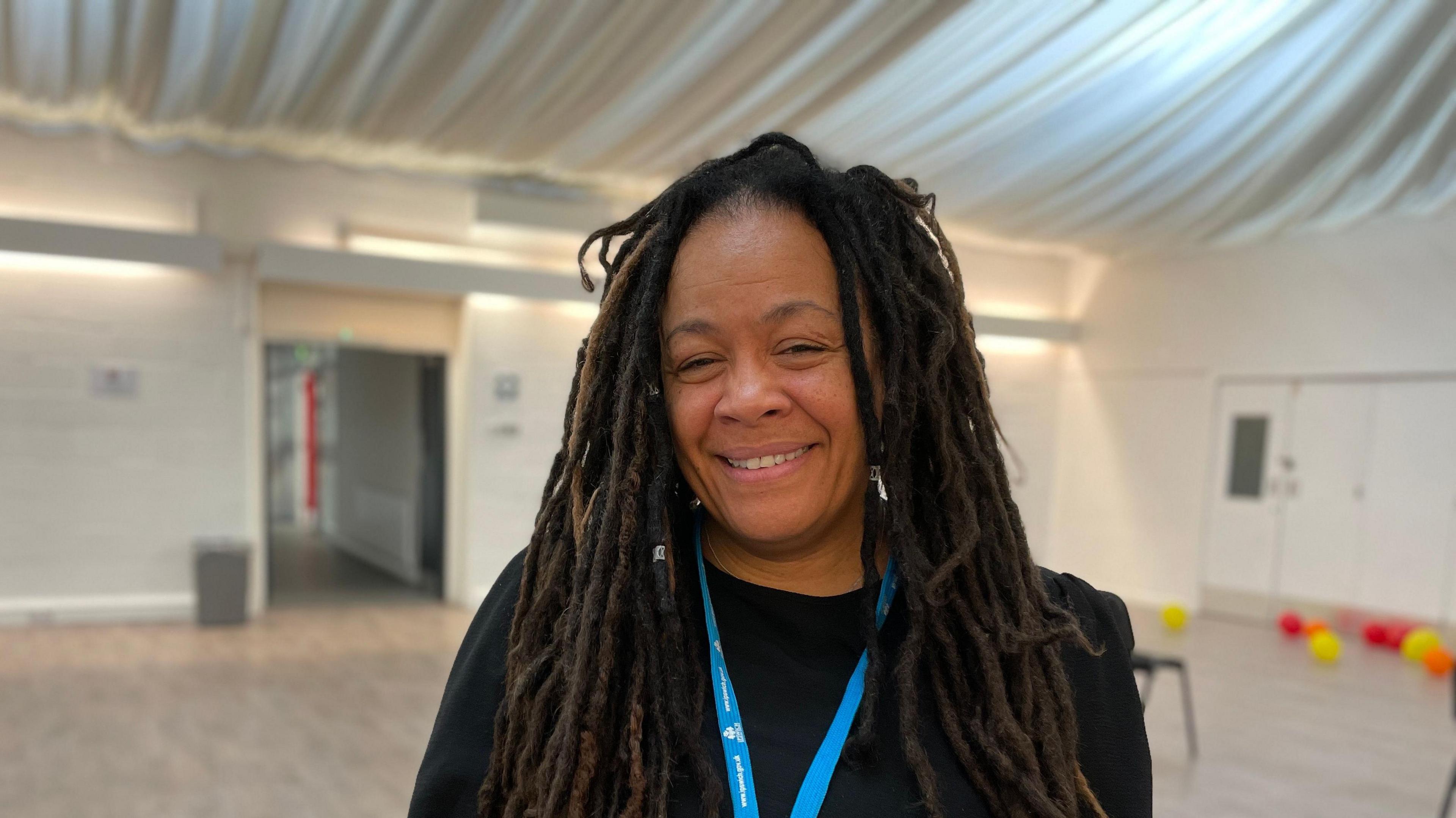 Tonia Wilson with a blue coloured lanyard standing in the hall