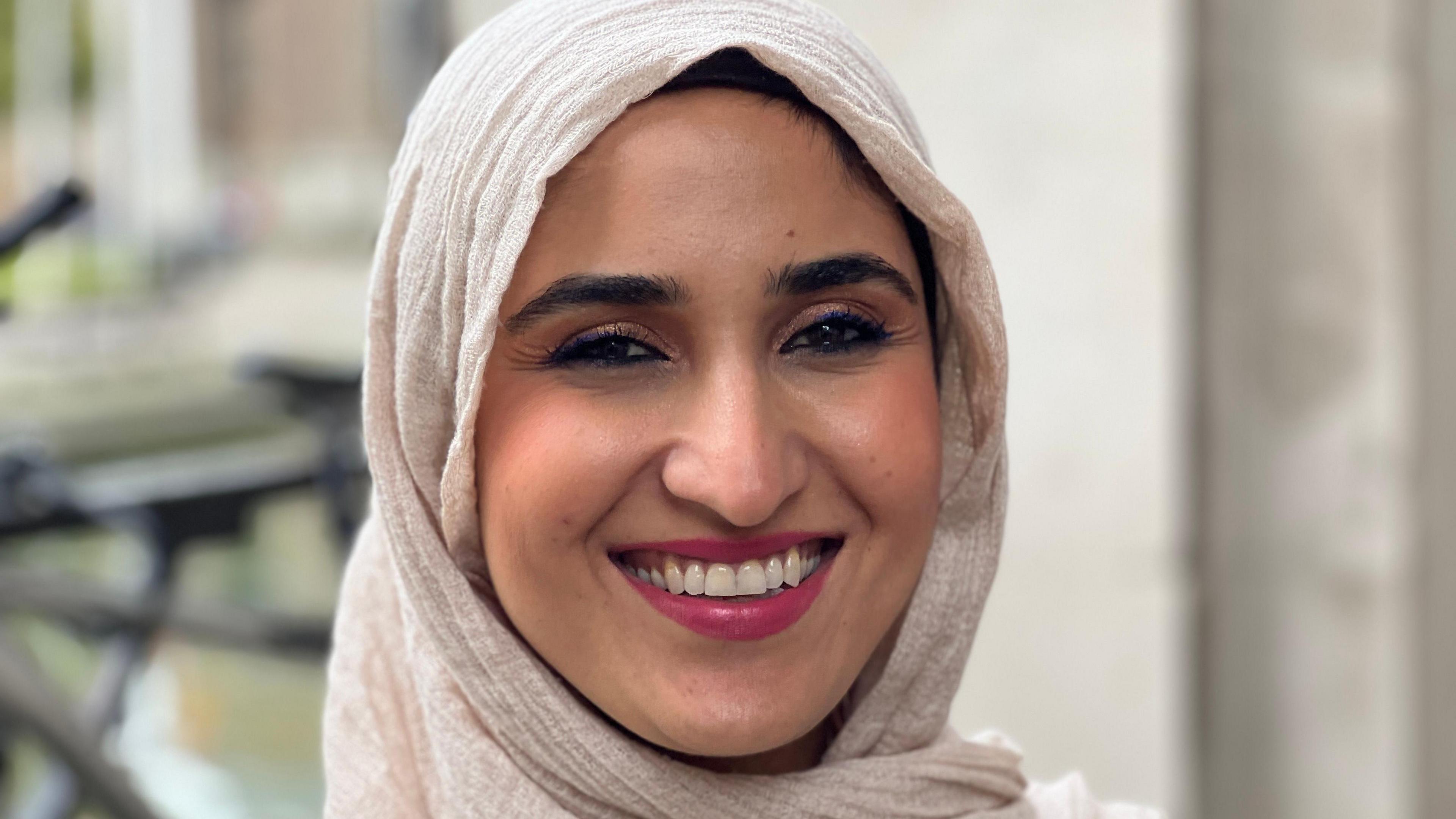 Campaign leader Tara Miran smiling, wearing a beige headscarf