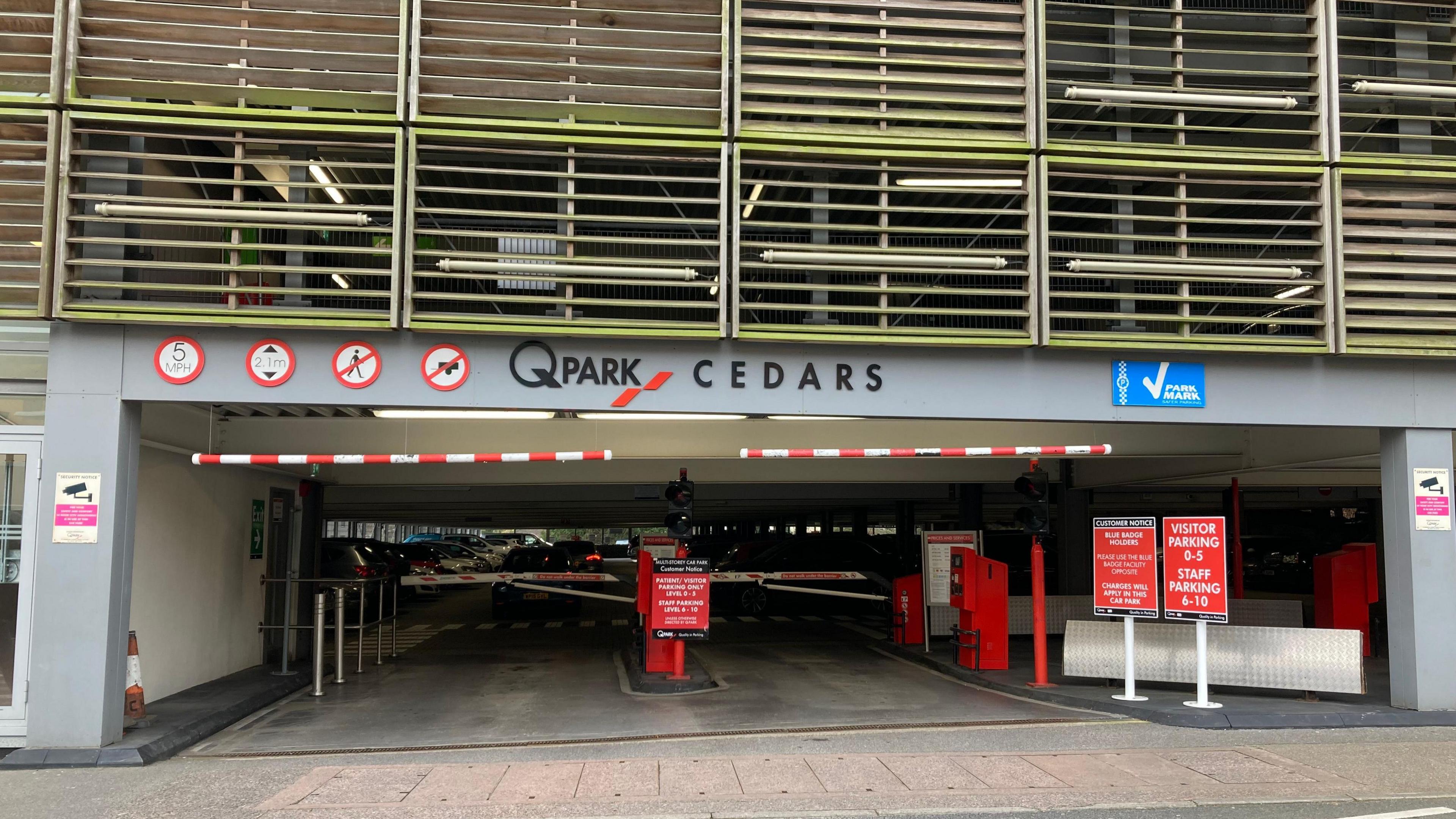 Multi-storey car park at Musgrove Park Hospital, with Q-Park and Cedars written along grey painted entrance.