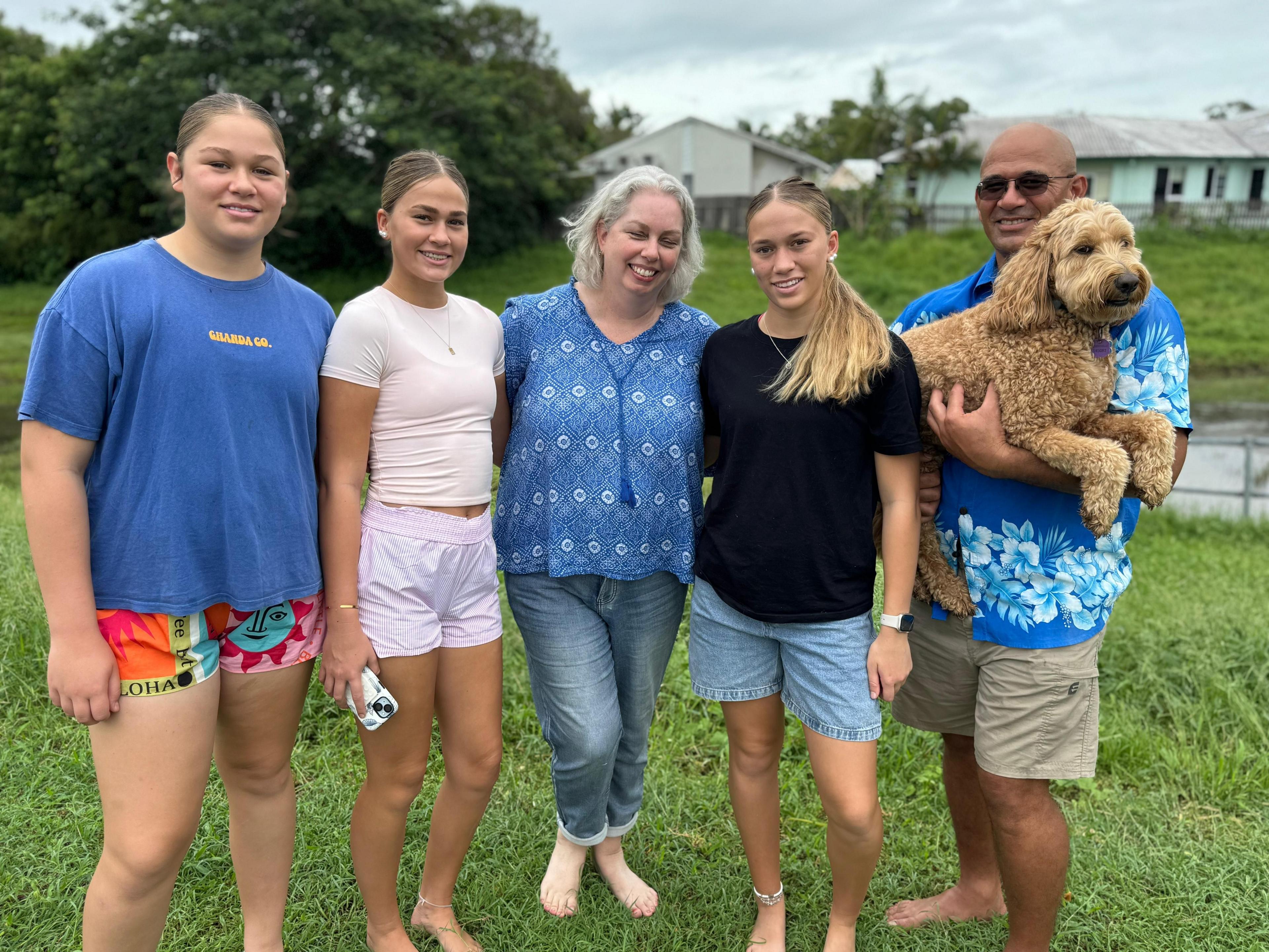 Jo Berry and her family and dog stand on grass in Townsville, smiling